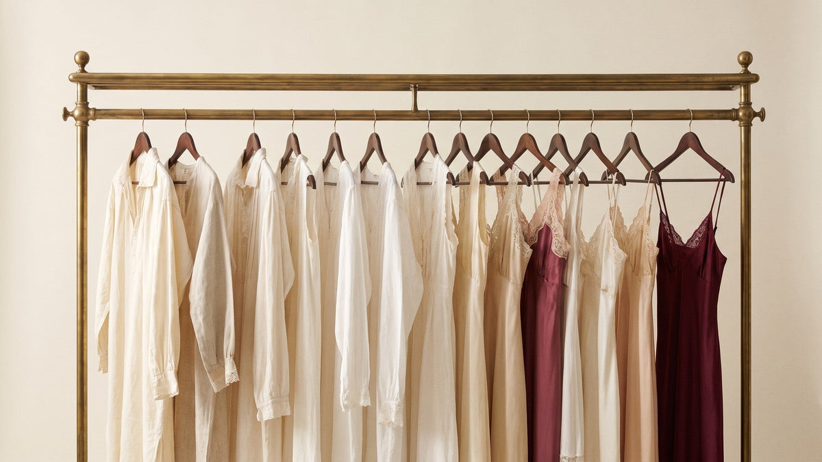 Vêtements de nuit ivoire, champagne et bordeaux sur un portant en laiton