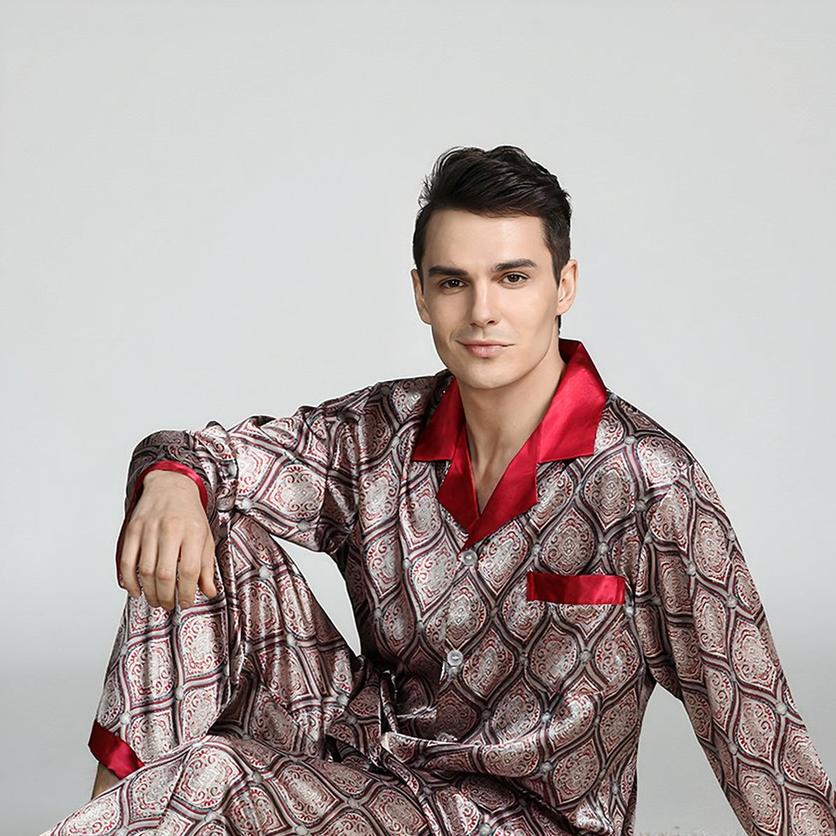 Homme assis en pyjama homme satiné beige à motifs, veste et pantalon assortis