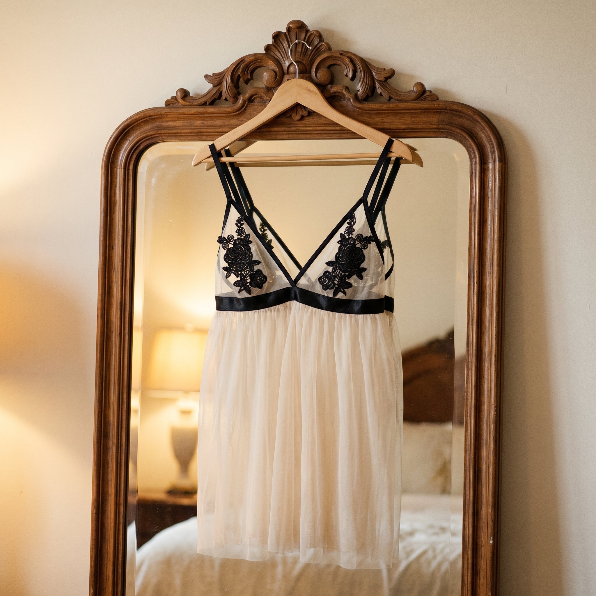 La nuisette suspendue à un cintre devant le grand miroir de la chambre, ses courbes dessinées par le voile clair et la lumière chaude d’une lampe renvoyée par la glace Image