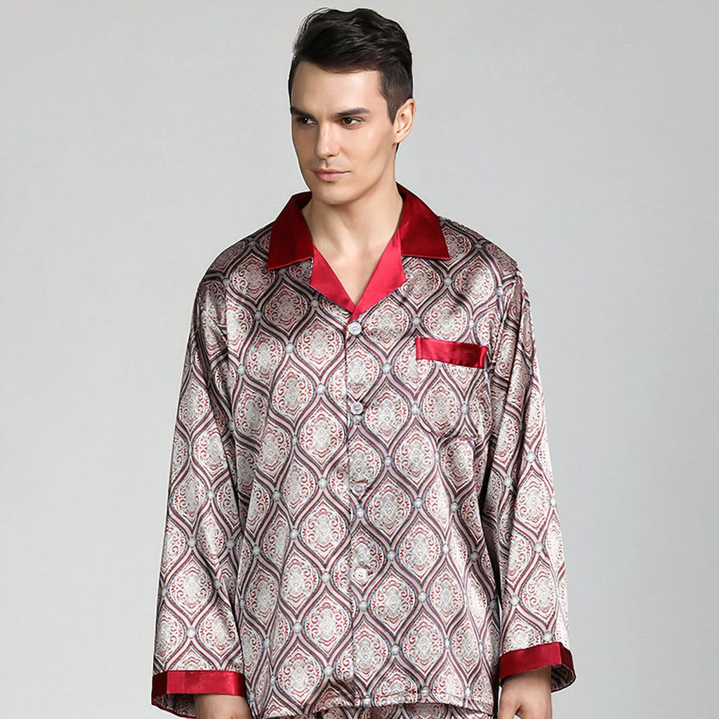 Homme debout de face en pyjama homme satiné beige à médaillons, col et poignets rouges