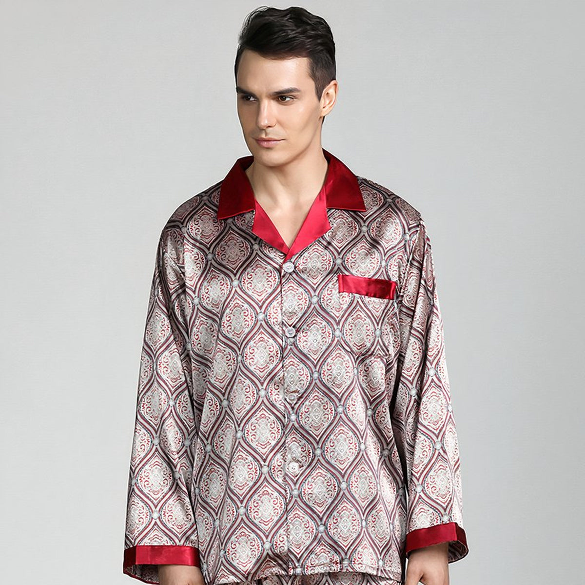 Homme debout de face en pyjama homme satiné beige à médaillons, col et poignets rouges