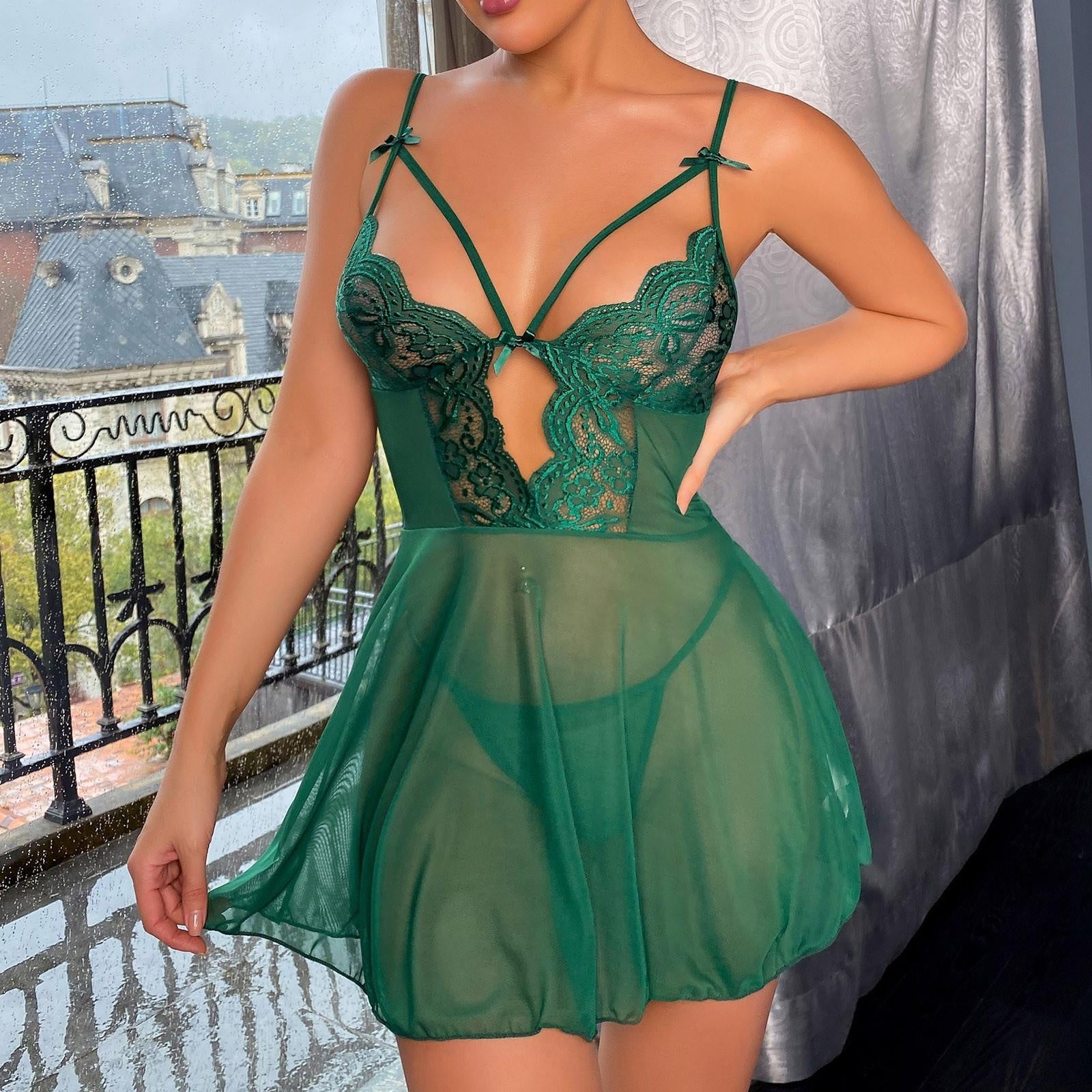 Femme portant la nuisette verte en dentelle devant un miroir Image