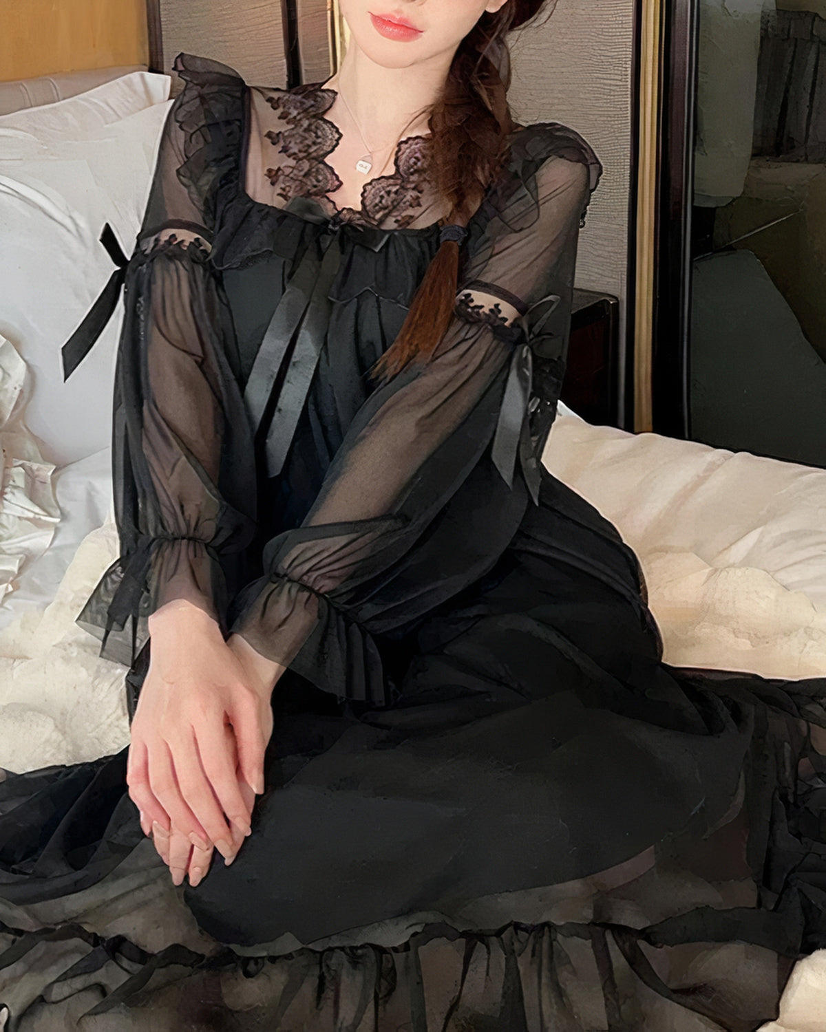 Empiècement de dentelle, volant froncé et ruban noué de la nuisette longue noire, vus de près