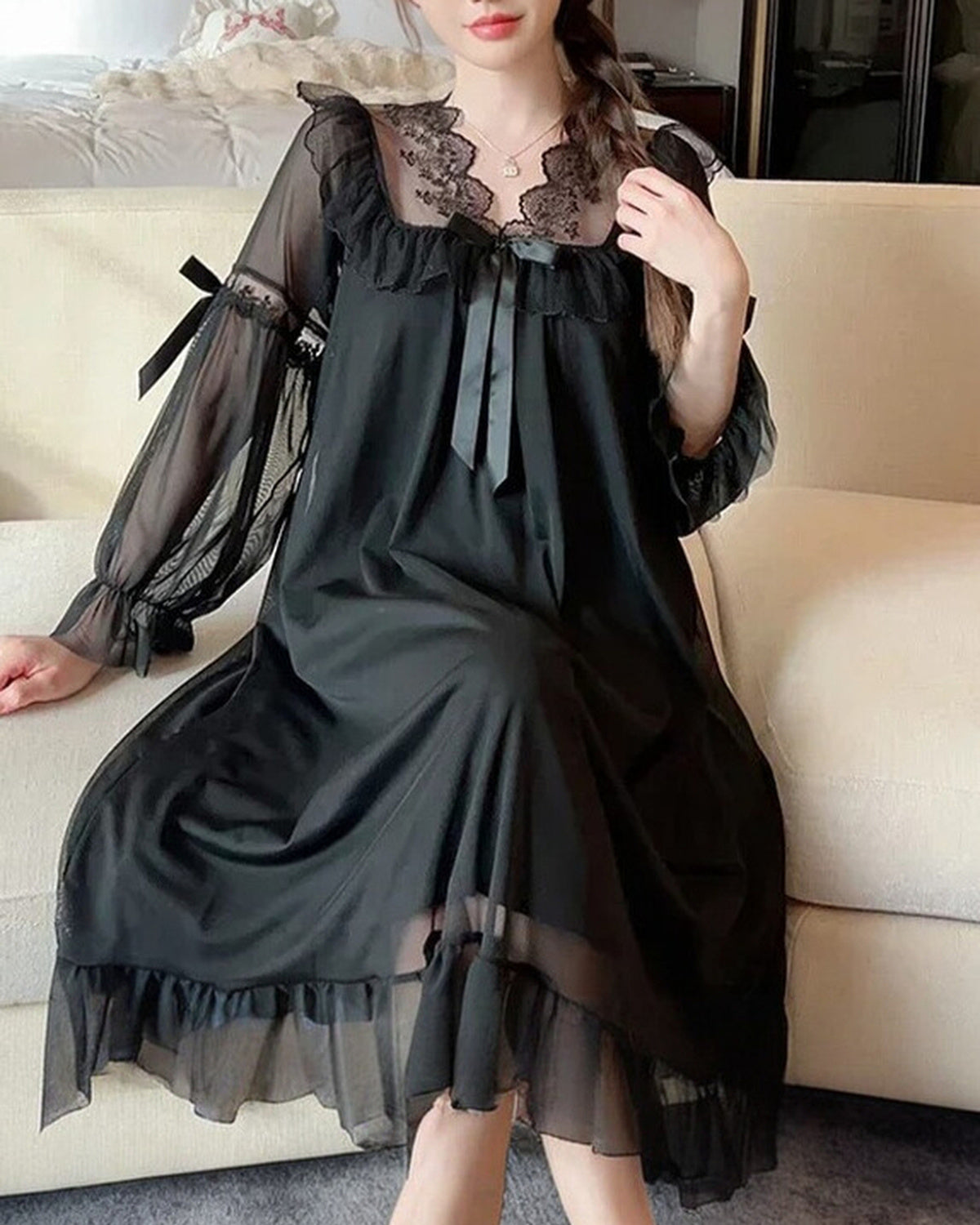 Nuisette longue noire portée assise, la pièce entière et son volant transparent au bas