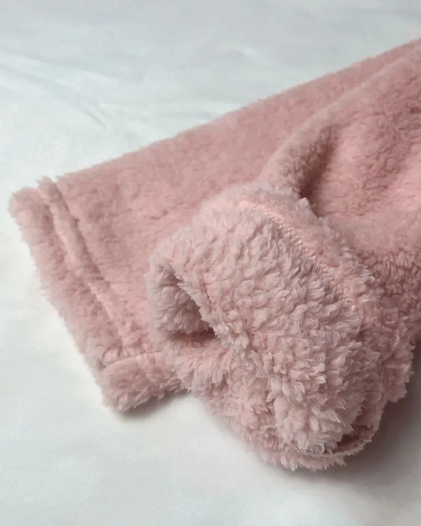 Chemise de nuit en peluche rose pliée, épaisseur de la matière bien visible