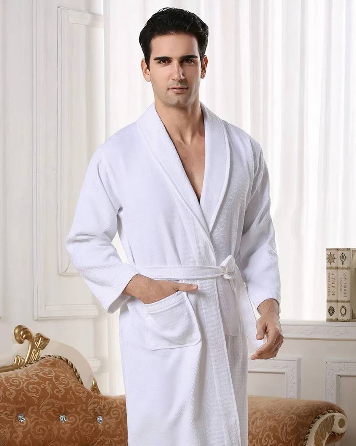 Homme portant le peignoir de bain blanc, une main dans la poche plaquée