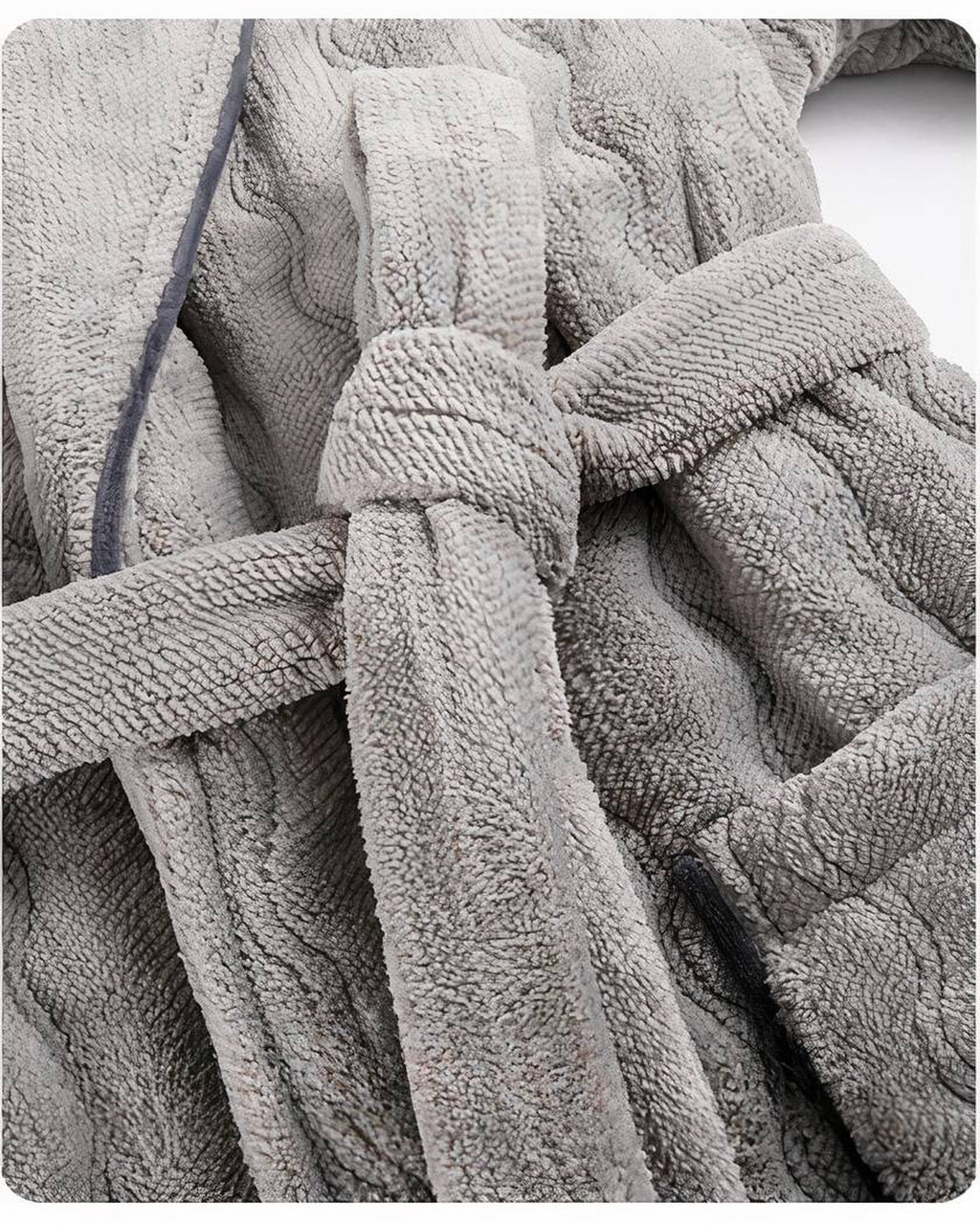 Détail du nœud de ceinture d'un peignoir polaire gris, le relief en vagues et le liseré foncé visibles de près