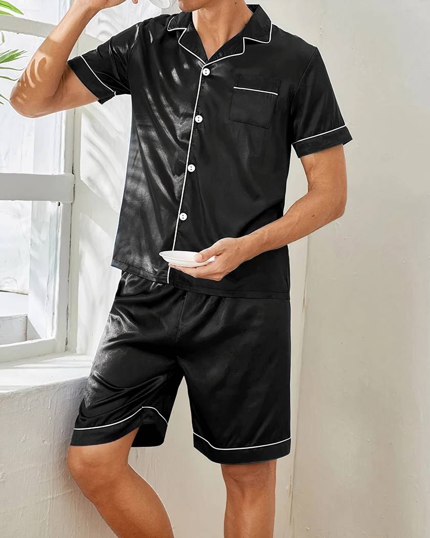 Pyjama homme d'été en satin noir porté près de la fenêtre, chemise et short
