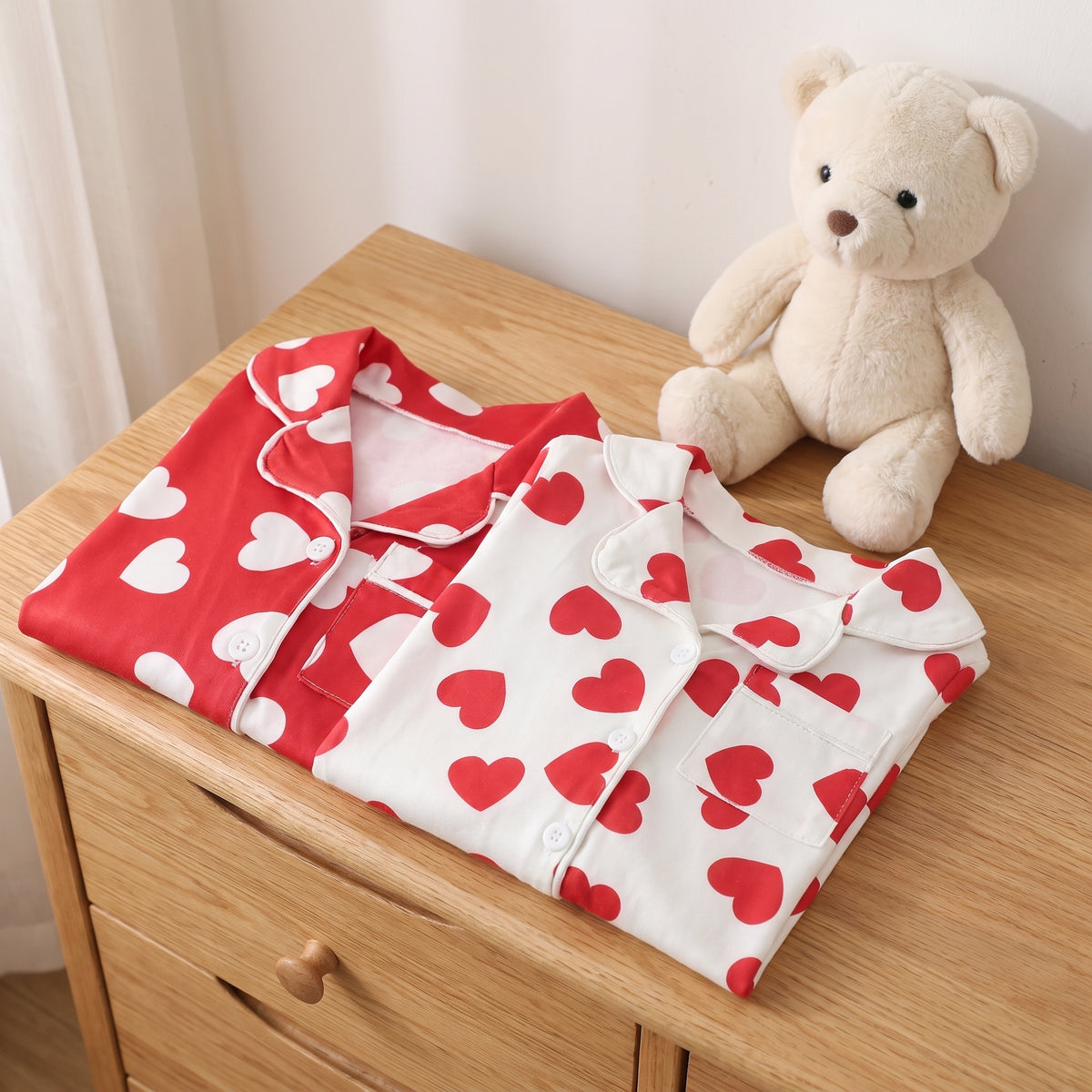 Les deux barboteuses pliees sur une commode a cote d'un doudou Image