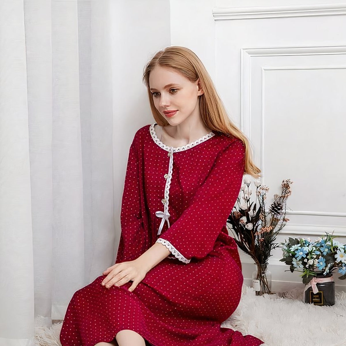 Femme blonde assise portant la nuisette longue rouge a pois, ambiance boudoir cosy Image