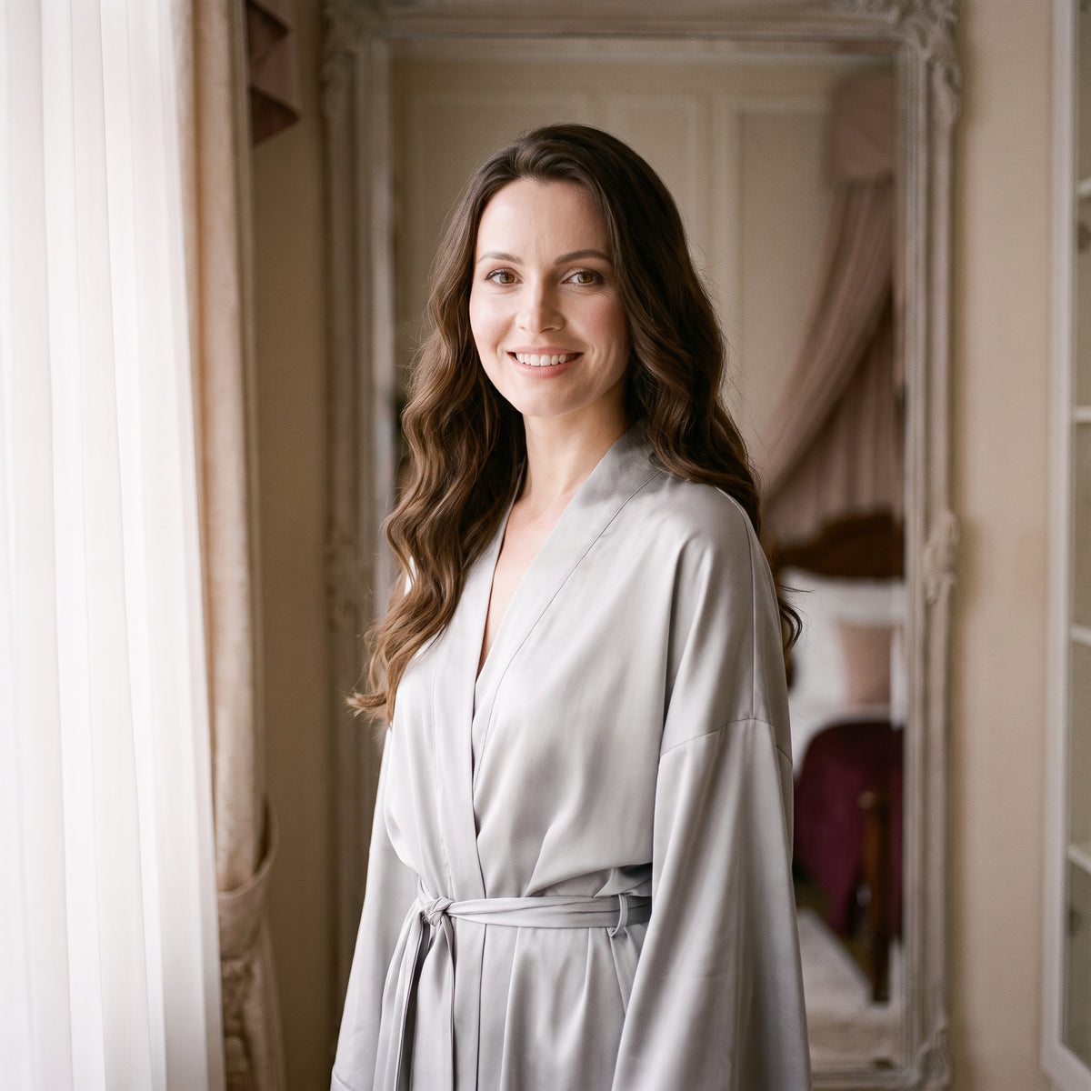 Peignoir kimono gris clair porté debout devant un grand miroir ancien, dans la lumière du matin