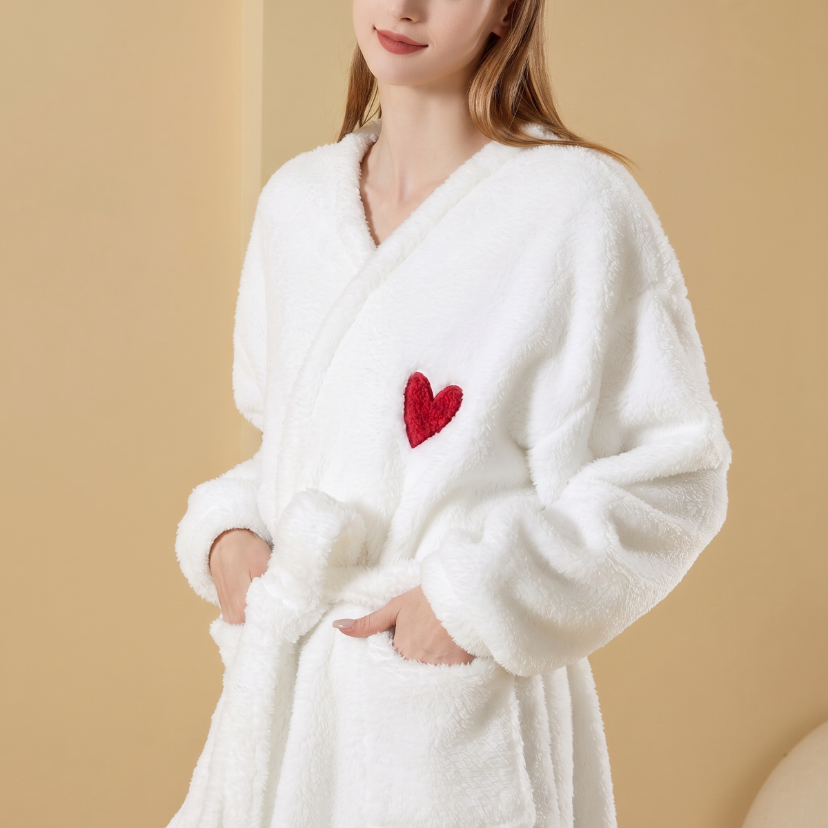 Femme enveloppée de face dans le peignoir polaire blanc, col croisé et mains dans les deux poches