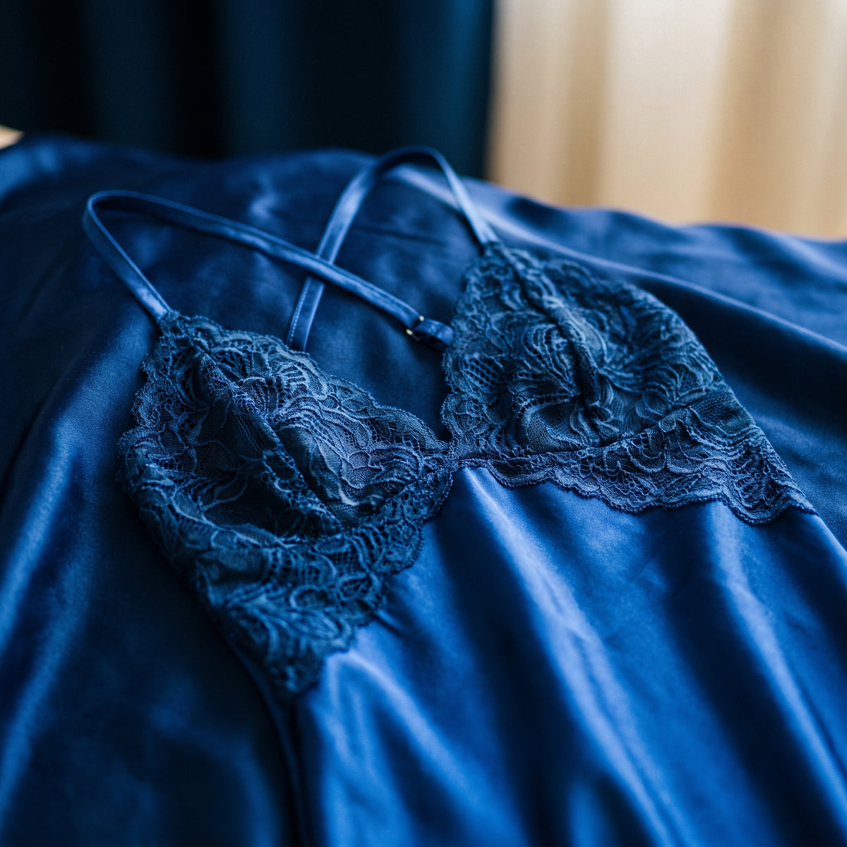Détail des bonnets en dentelle bleue sur satin bleu roi