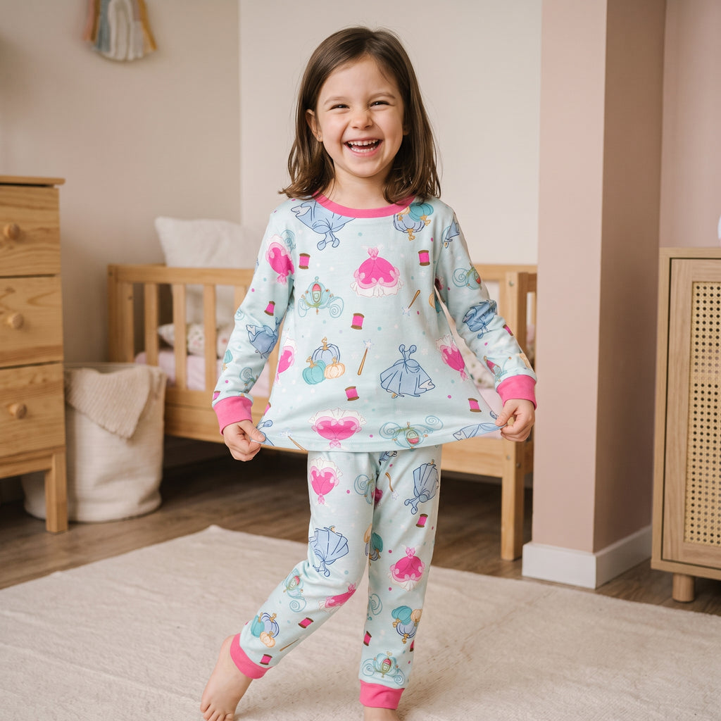 Petite fille en pyjama princesse qui écarte l'ourlet de son haut comme une robe de bal, en plein rire