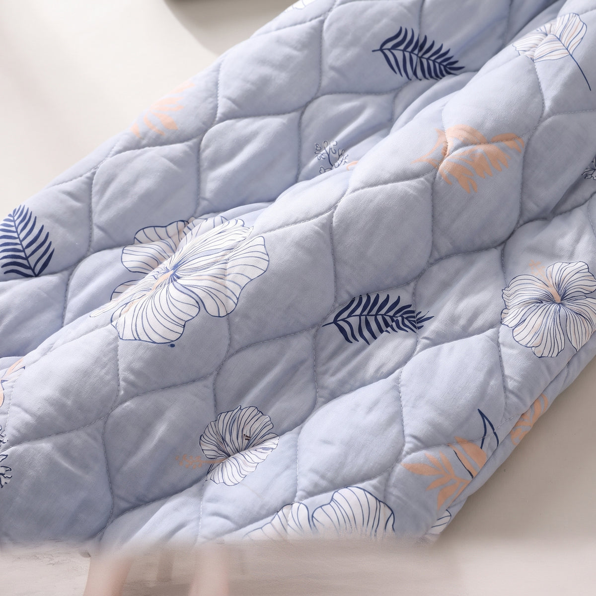 Détail du matelassage en losanges et de l'imprimé hibiscus du coloris bleu ciel
