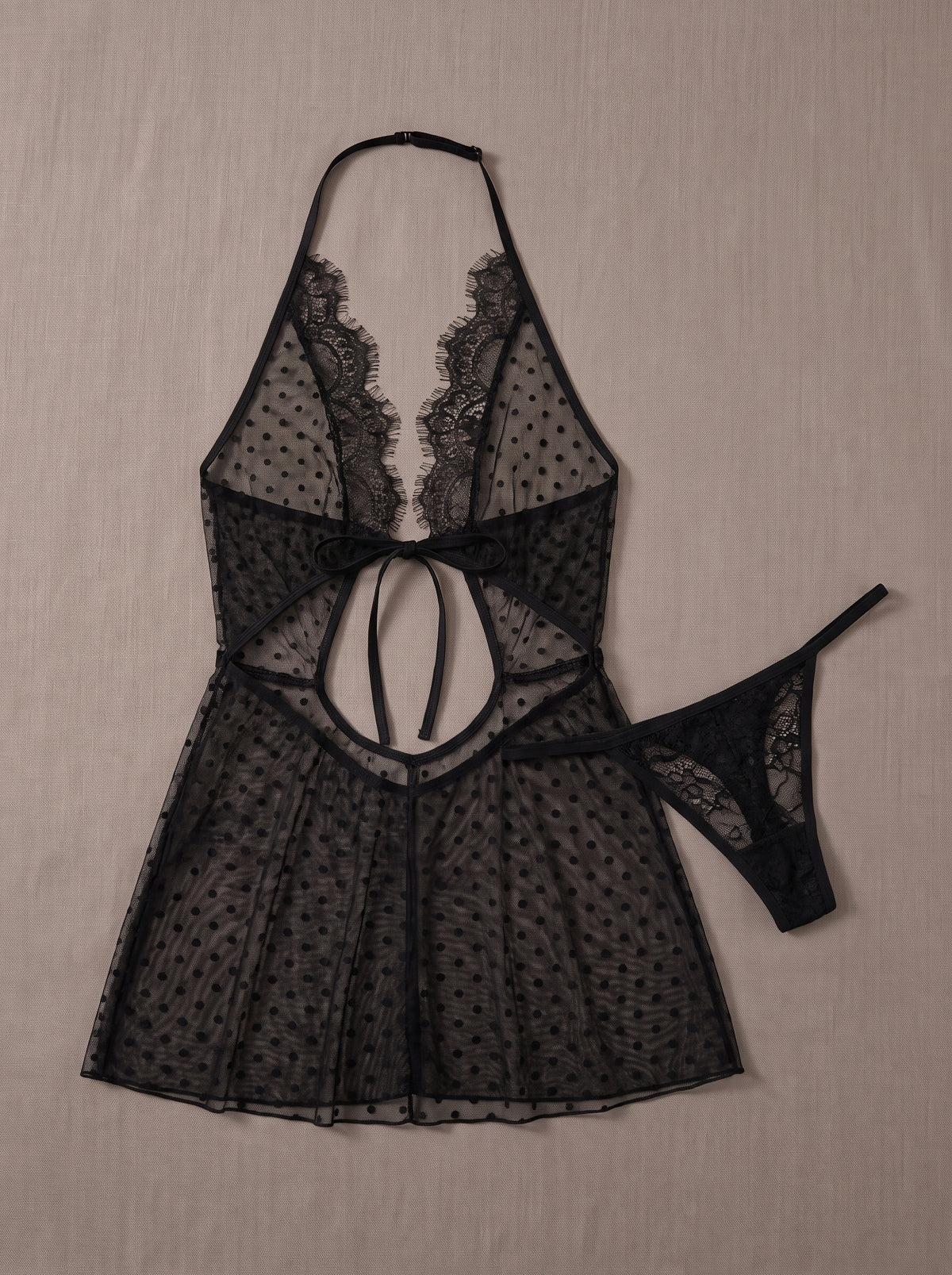 Ensemble nuisette noire transparente à pois et string assorti posés à plat