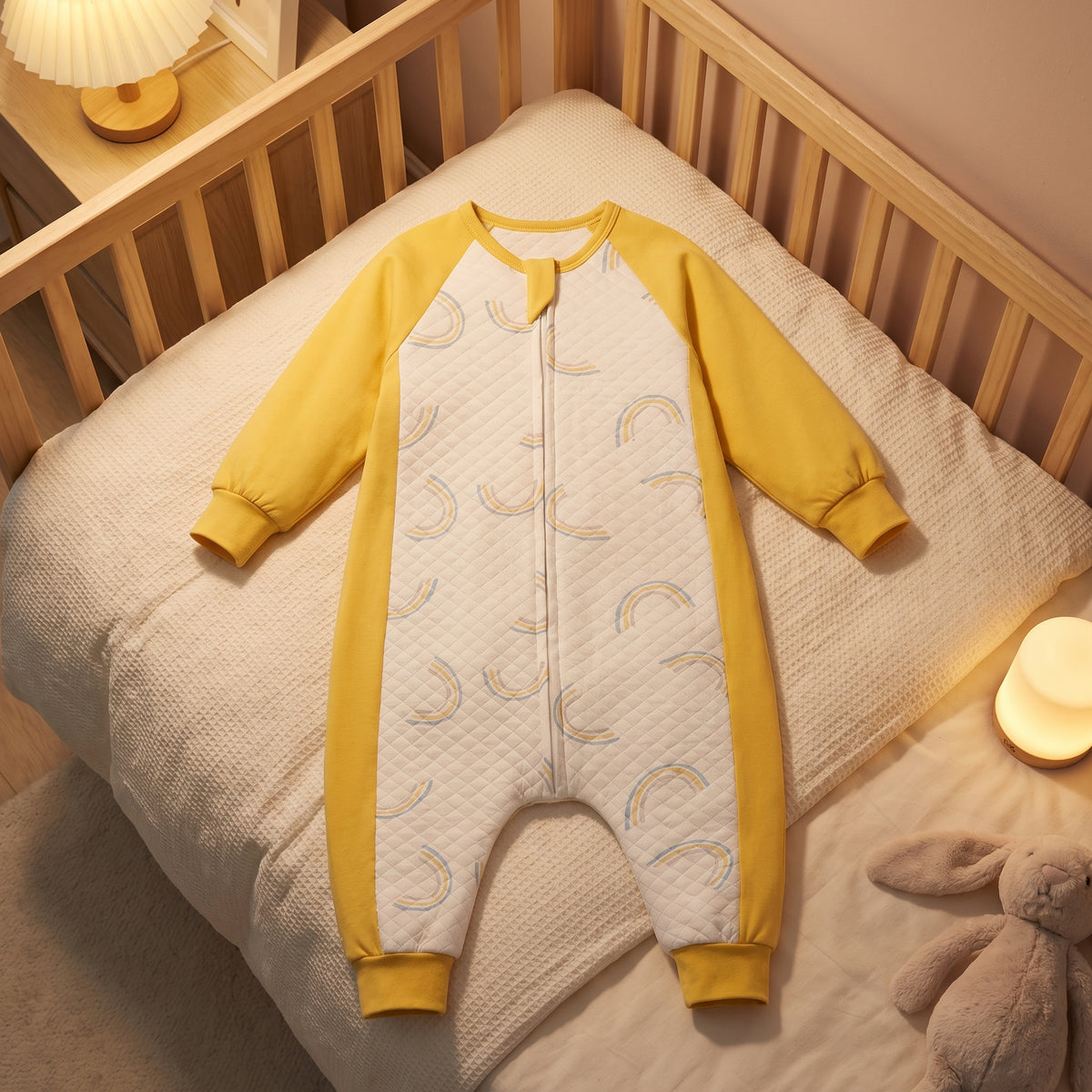 Pyjama enfant à arcs-en-ciel déplié sur un petit lit, veilleuse allumée à l'heure du coucher