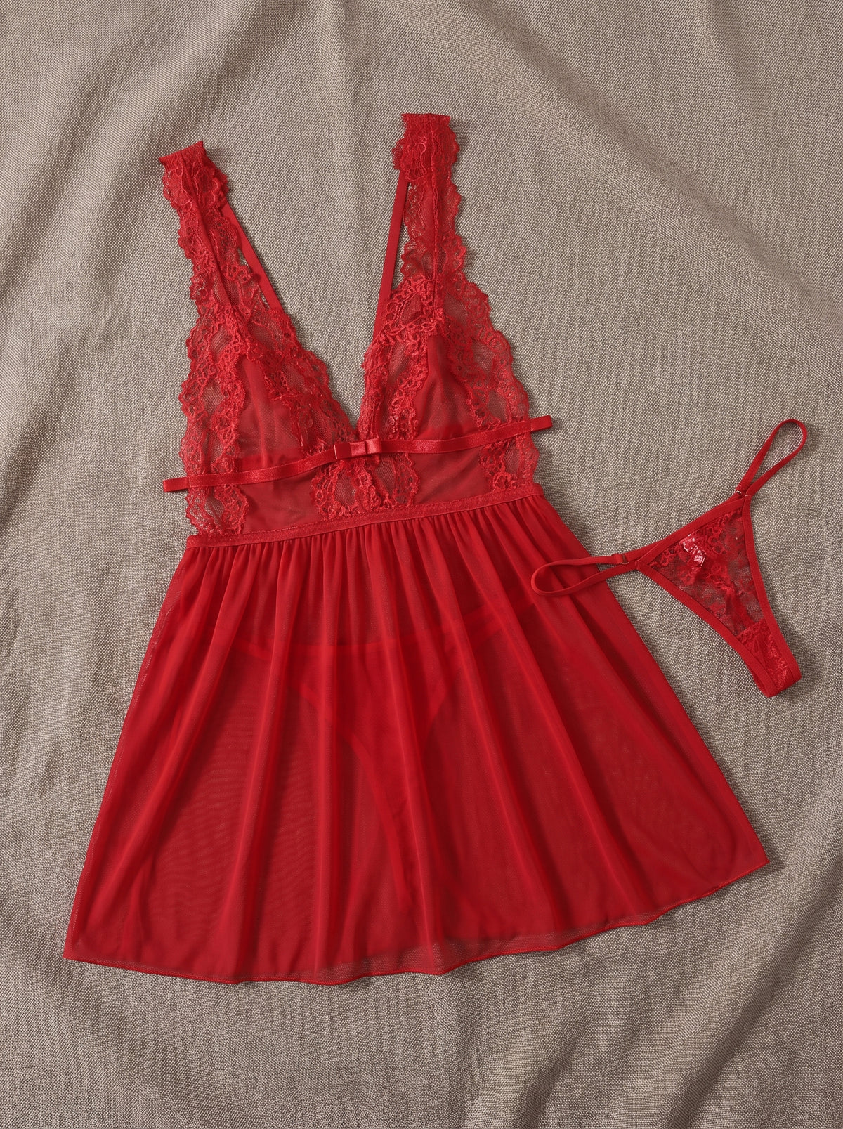 Ensemble mini nuisette rouge en dentelle et string assorti posés à plat