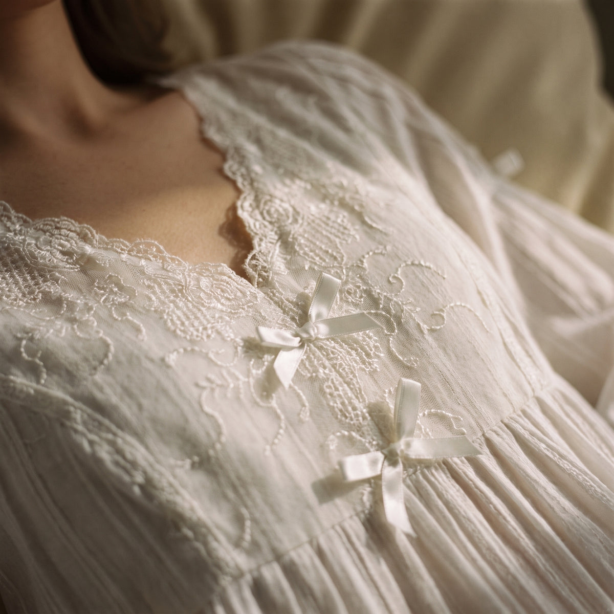 Décolleté en V bordé de dentelle et nœuds de satin de la nuisette blanche vintage