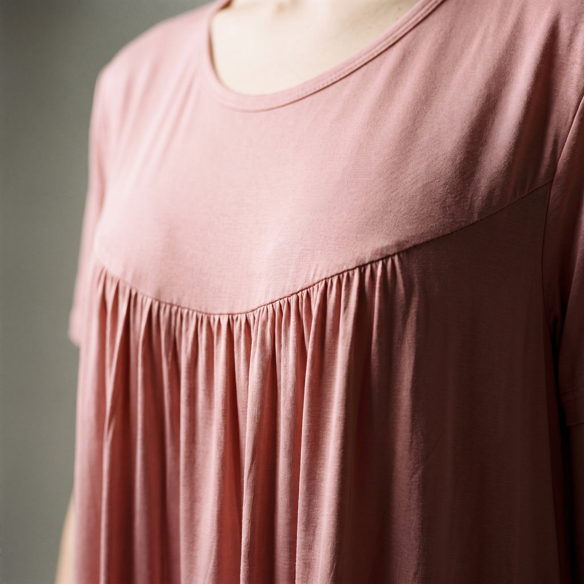 Fines fronces du décolleté de la chemise de nuit rose