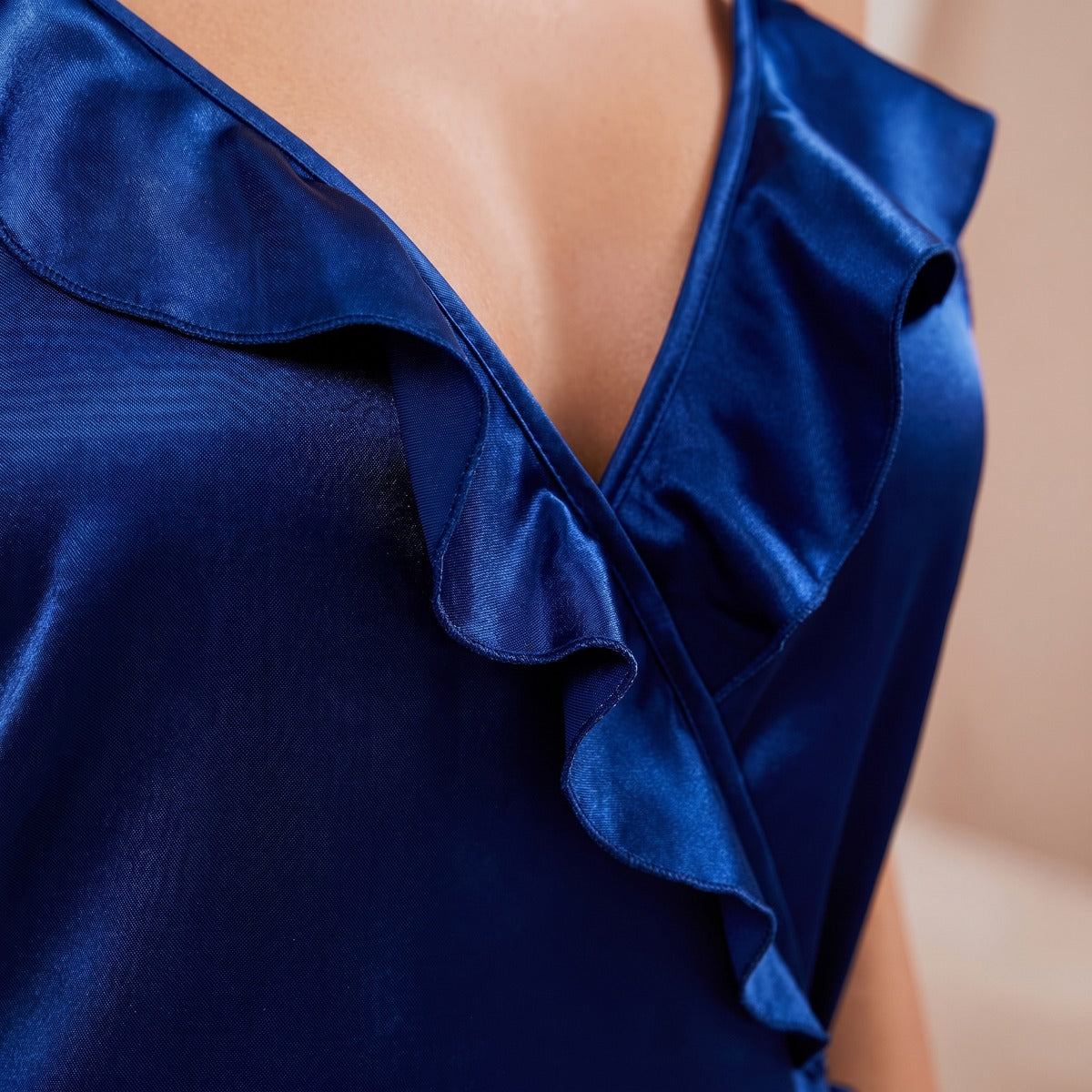 Gros plan des volants en satin bleu profond, détail signature de la nuisette portefeuille Image