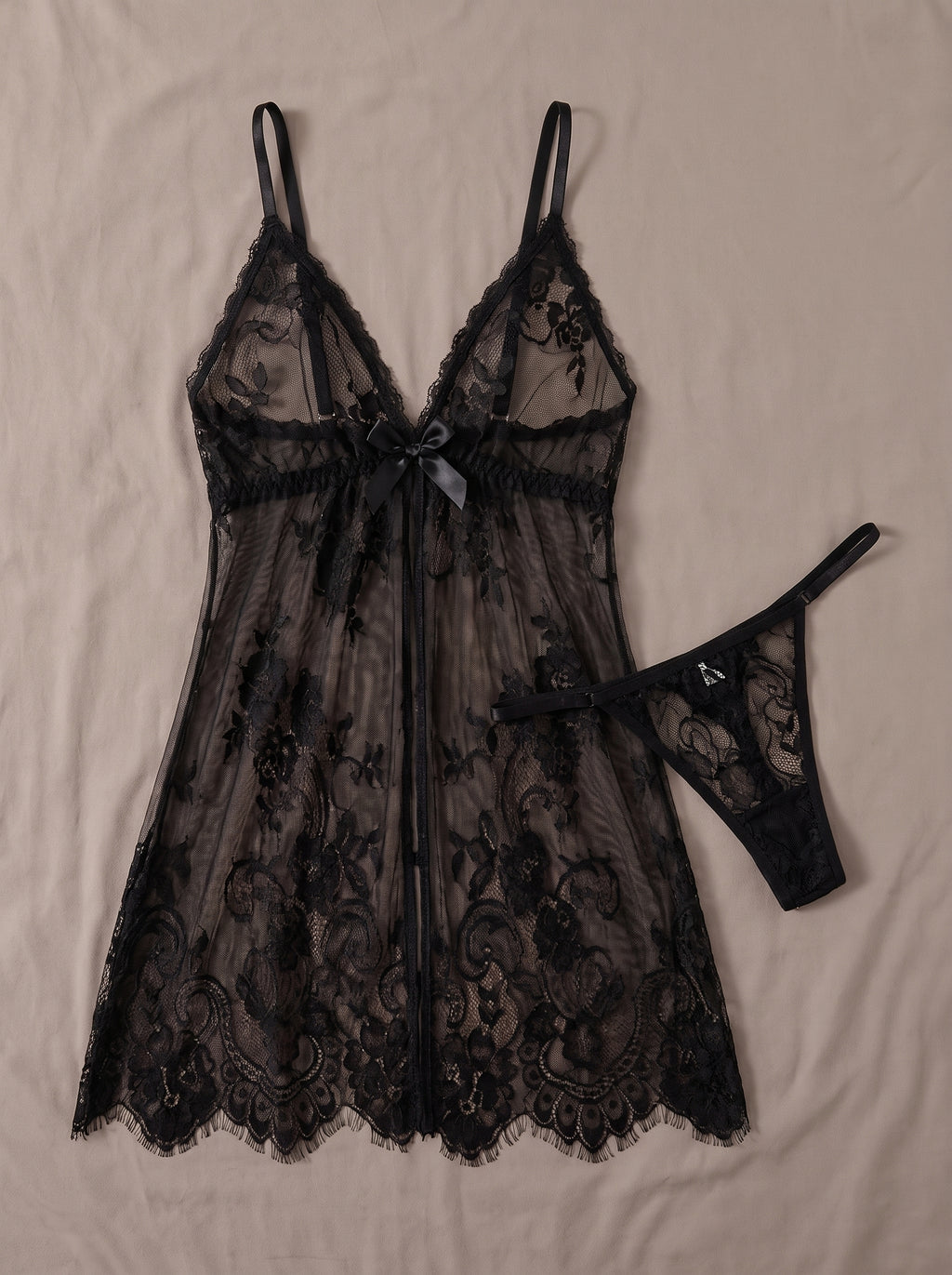 Ensemble nuisette noire transparente en dentelle et string assorti posés à plat