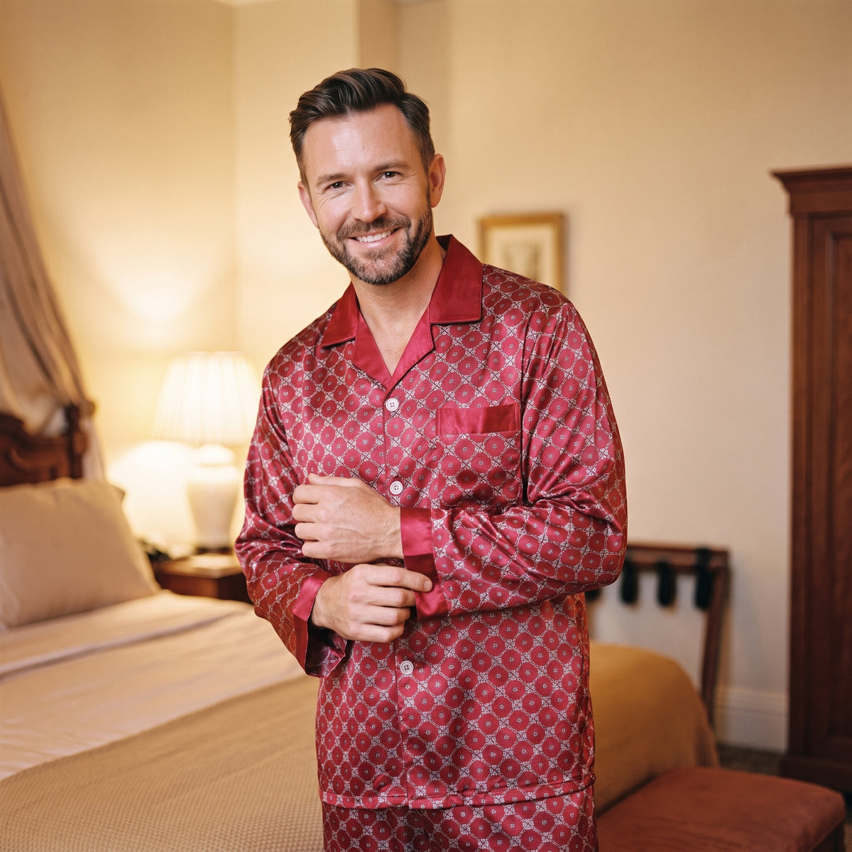 Homme debout dans sa chambre en fin de journée, il ajuste le poignet de sa chemise de pyjama satiné rouge, les boutons fermés