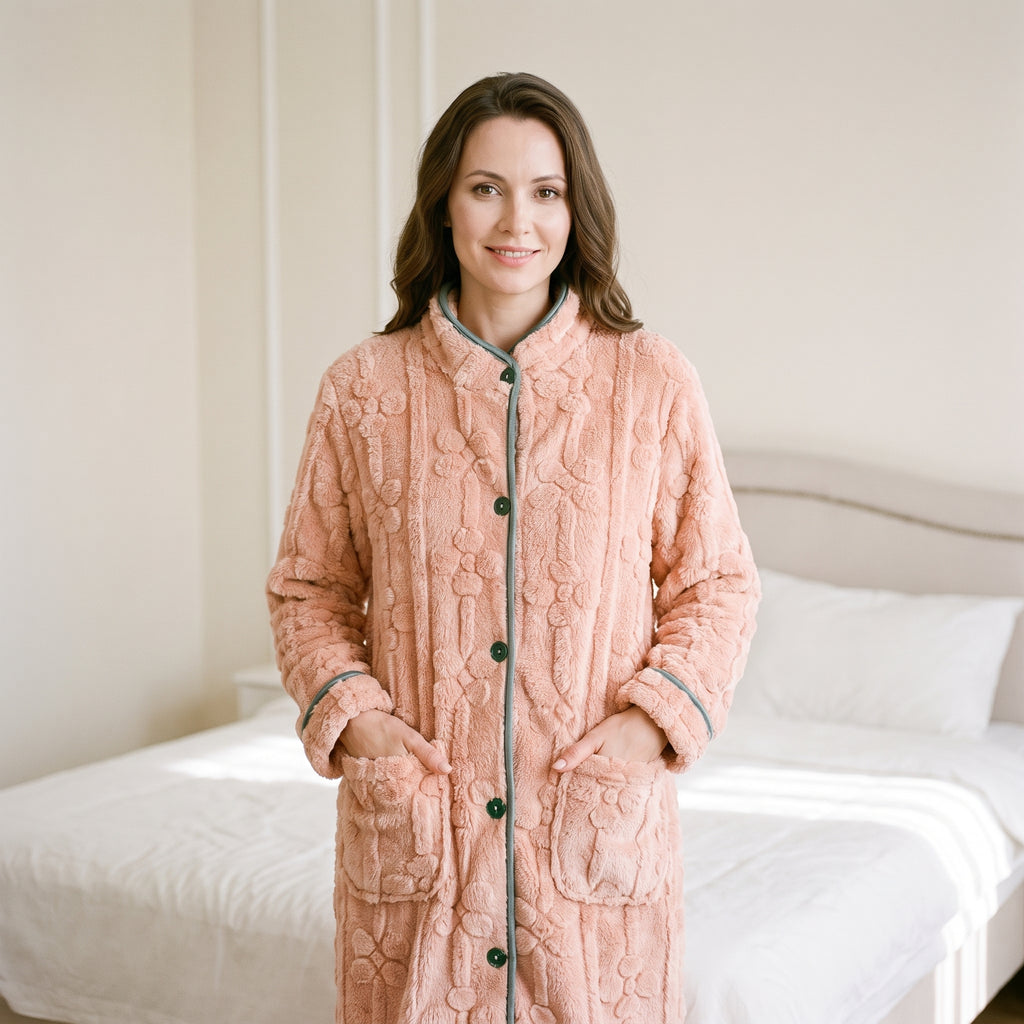 Robe de chambre boutonnée rose portée, mains dans les poches, boutons verts et liseré contrastant