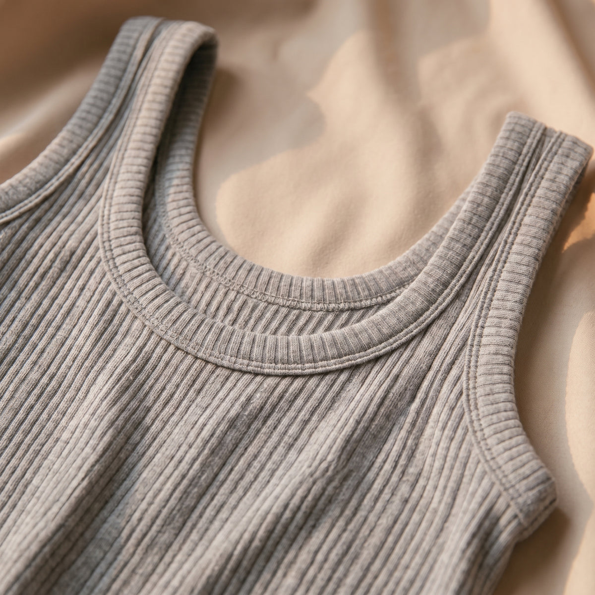 Détail de l'encolure ronde et de la maille qui caresse la peau, larges bretelles du pyjama deux-pièces gris