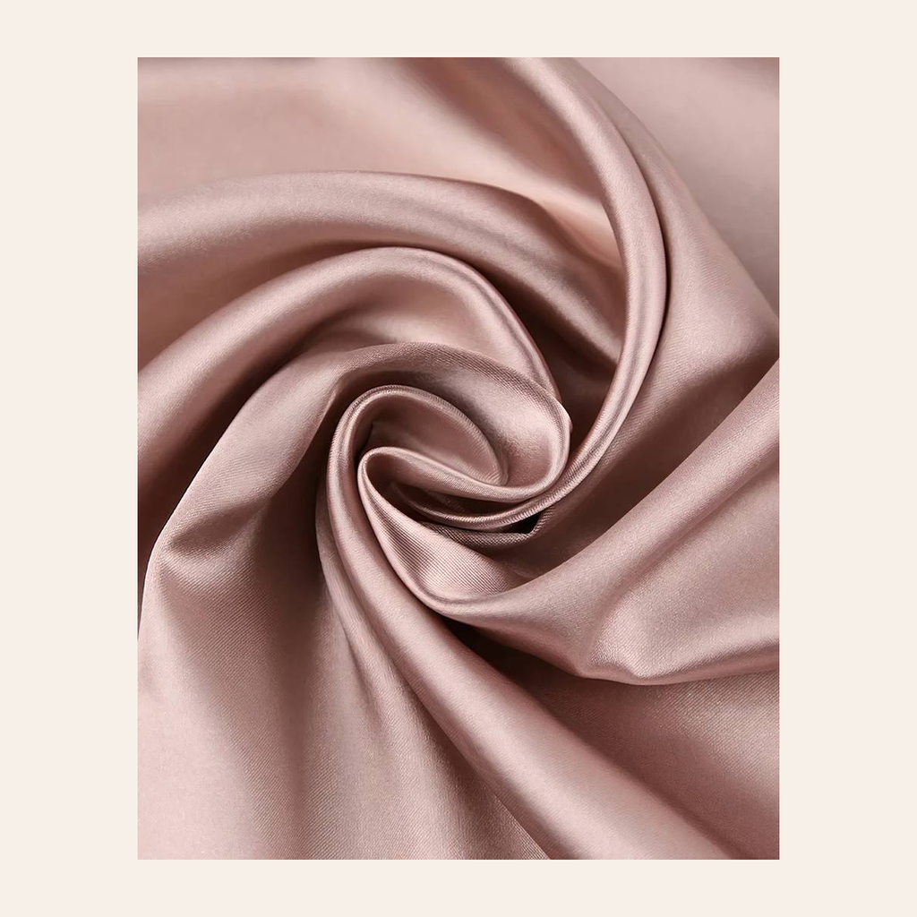 Reflets satinés du peignoir rose poudré dans une lumière douce