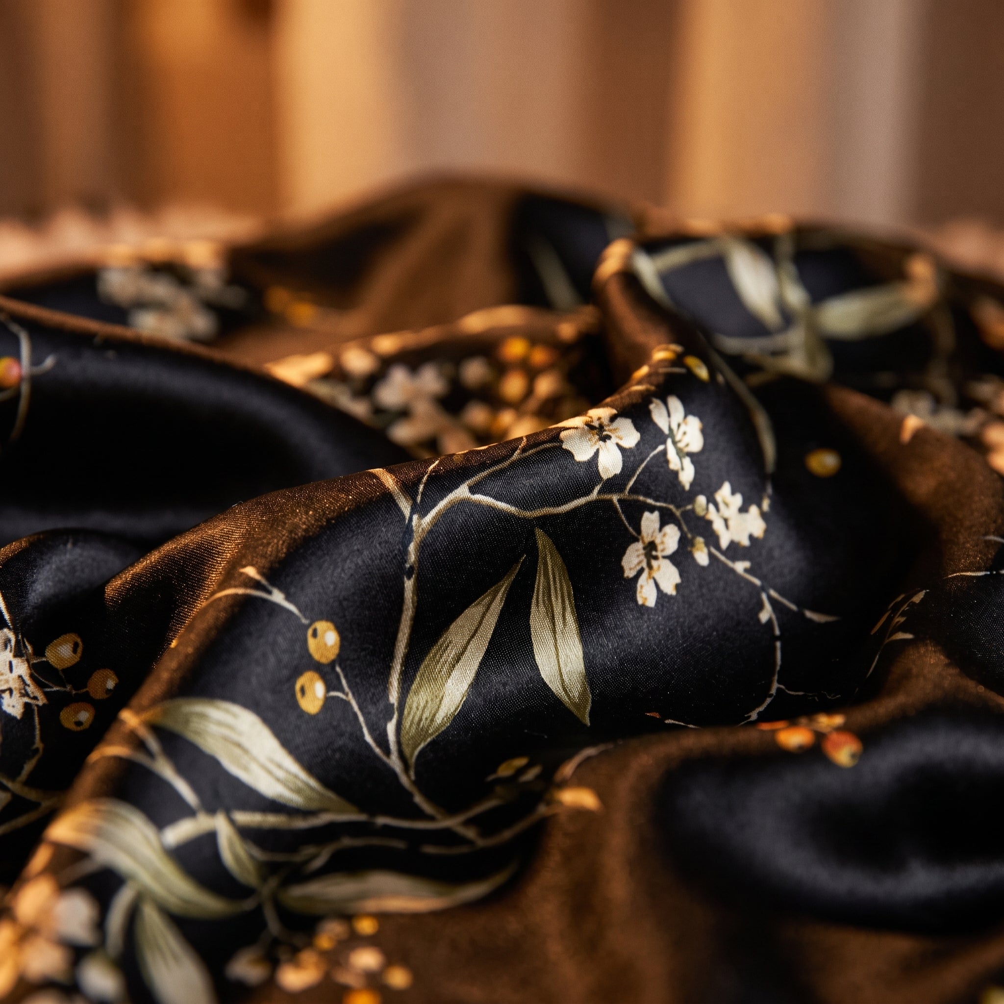 Détail de l'imprimé floral botanique sur satin noir, fleurs crème et baies dorées Image