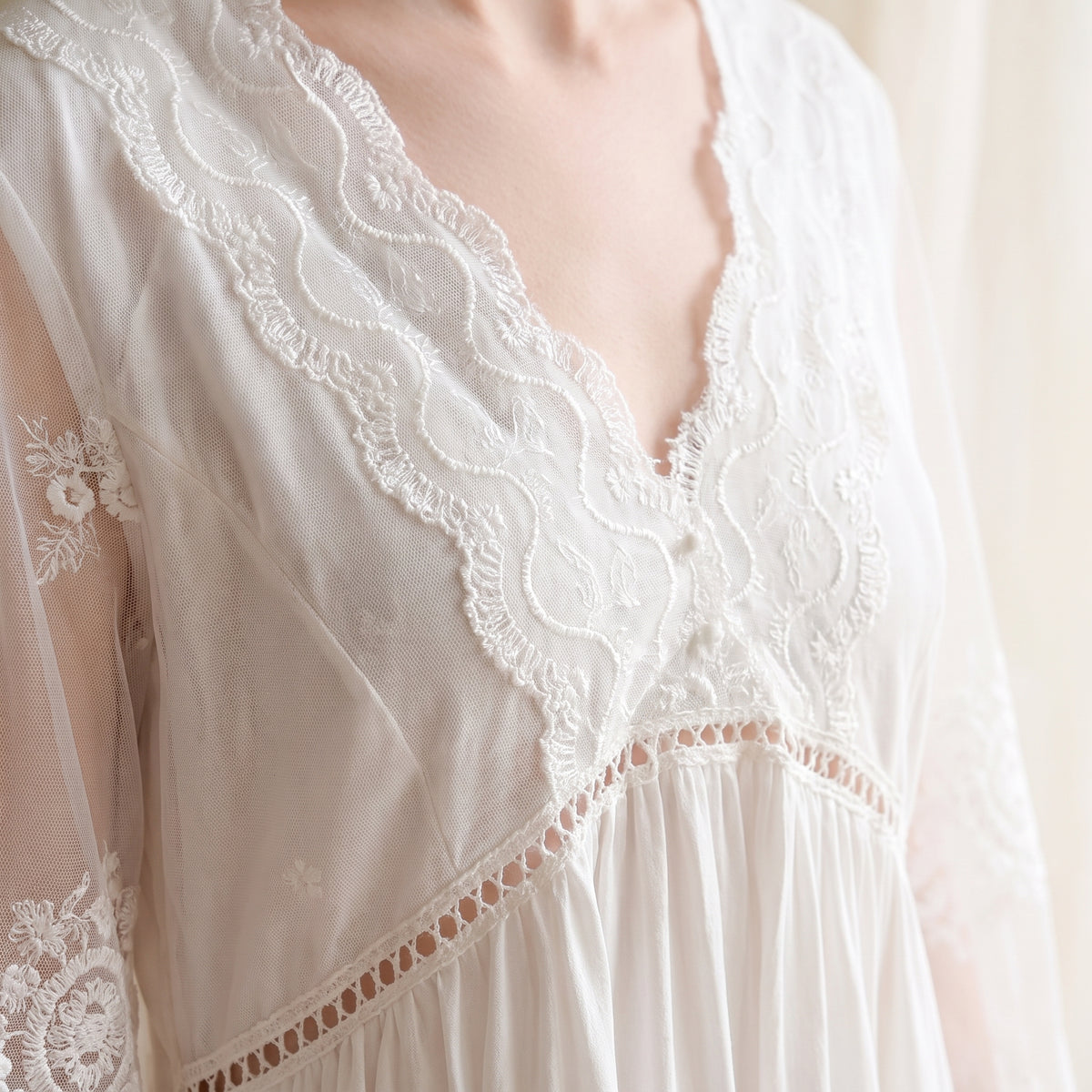 Détail du décolleté en V en dentelle et broderie et de la taille empire