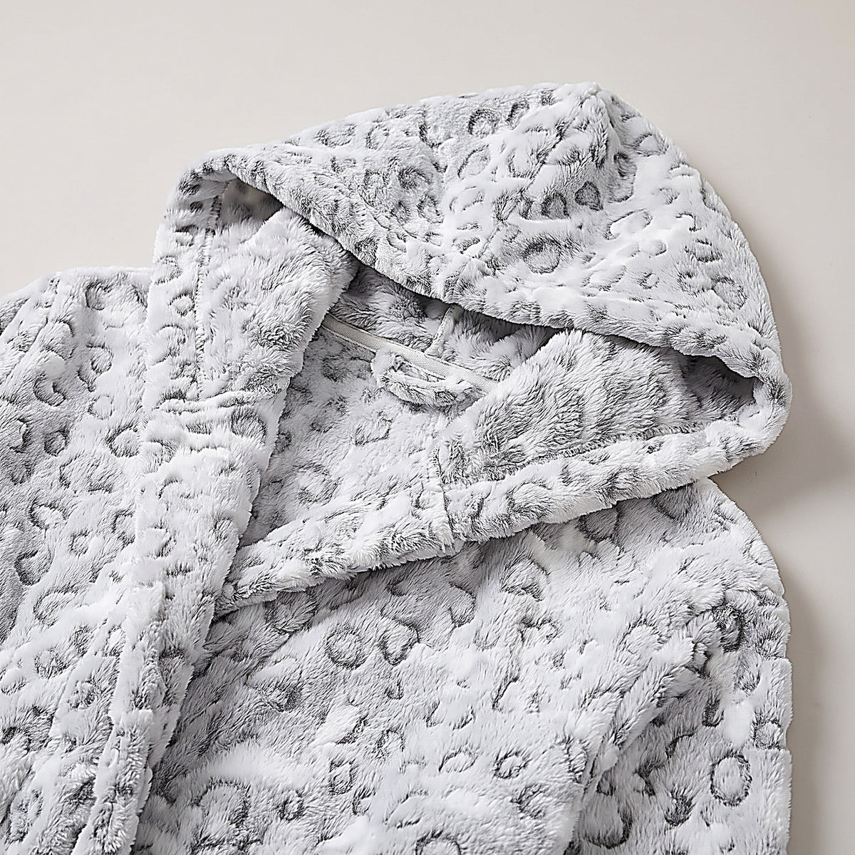 Détail de la polaire moelleuse à imprimé léopard gris et blanc et de la capuche