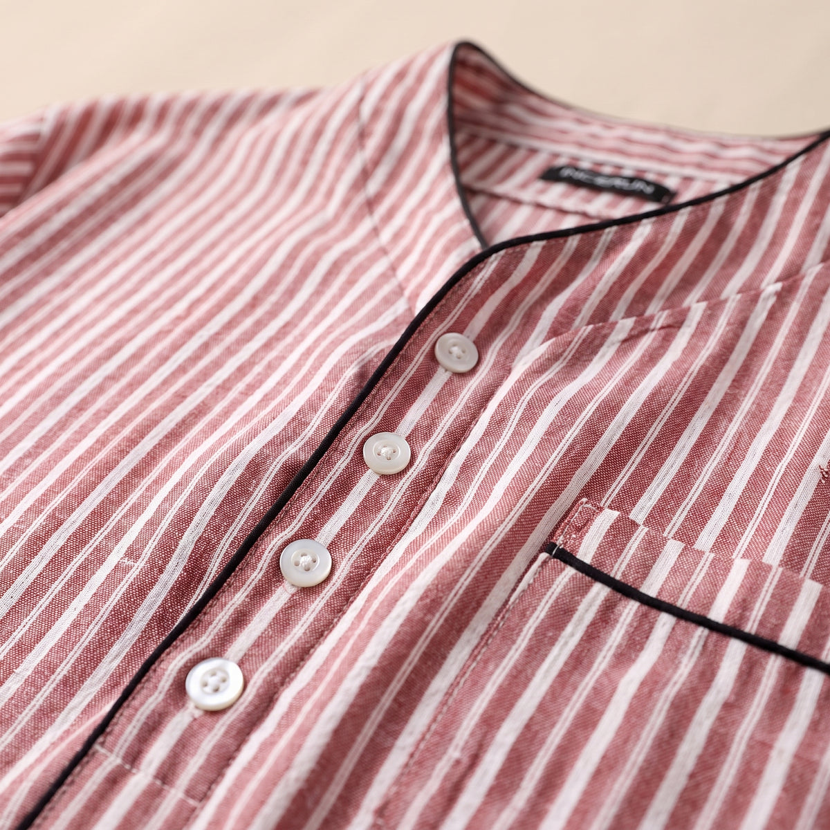 Détail du col mao, de la patte boutonnée et de la poche à passepoil