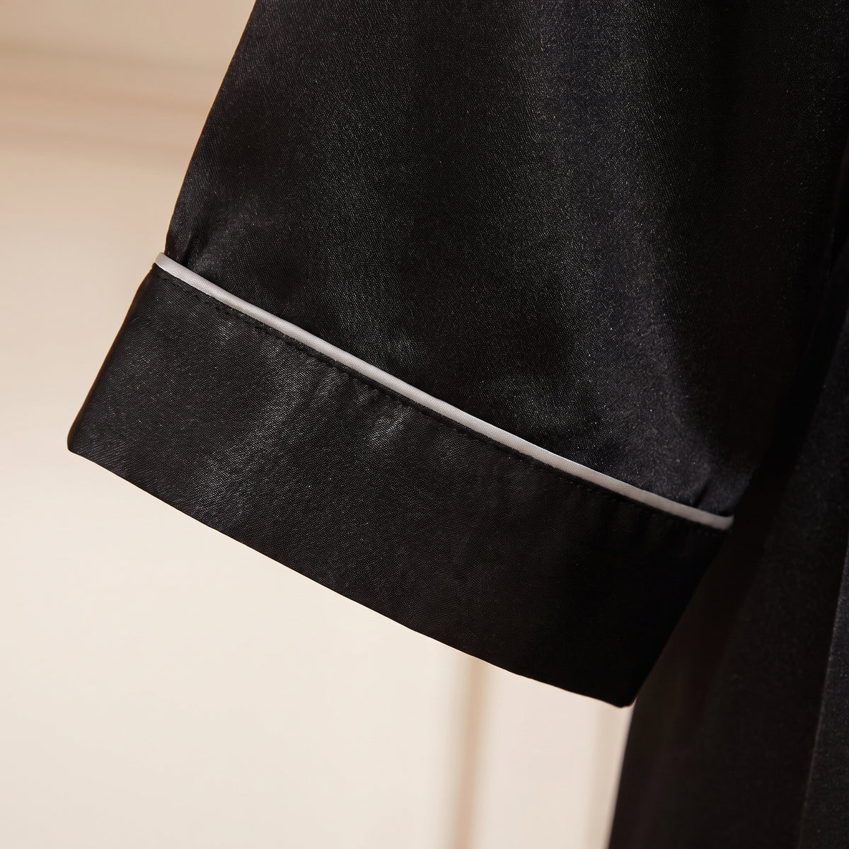 Détail du satin noir et du liseré clair au poignet