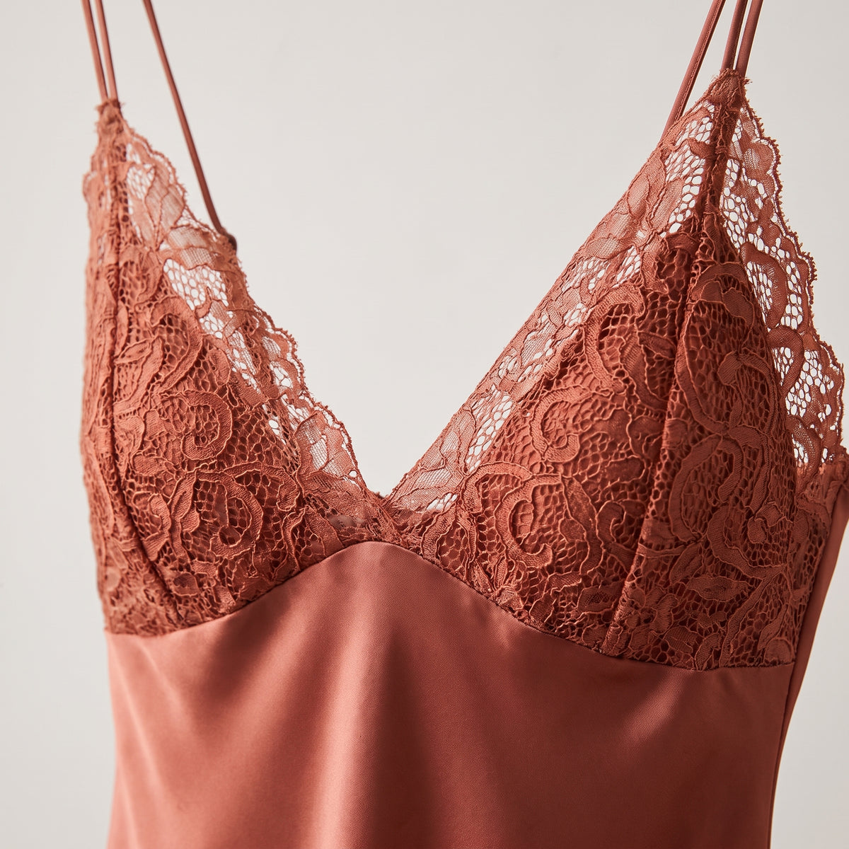Détail du décolleté en dentelle florale terracotta de la nuisette satin