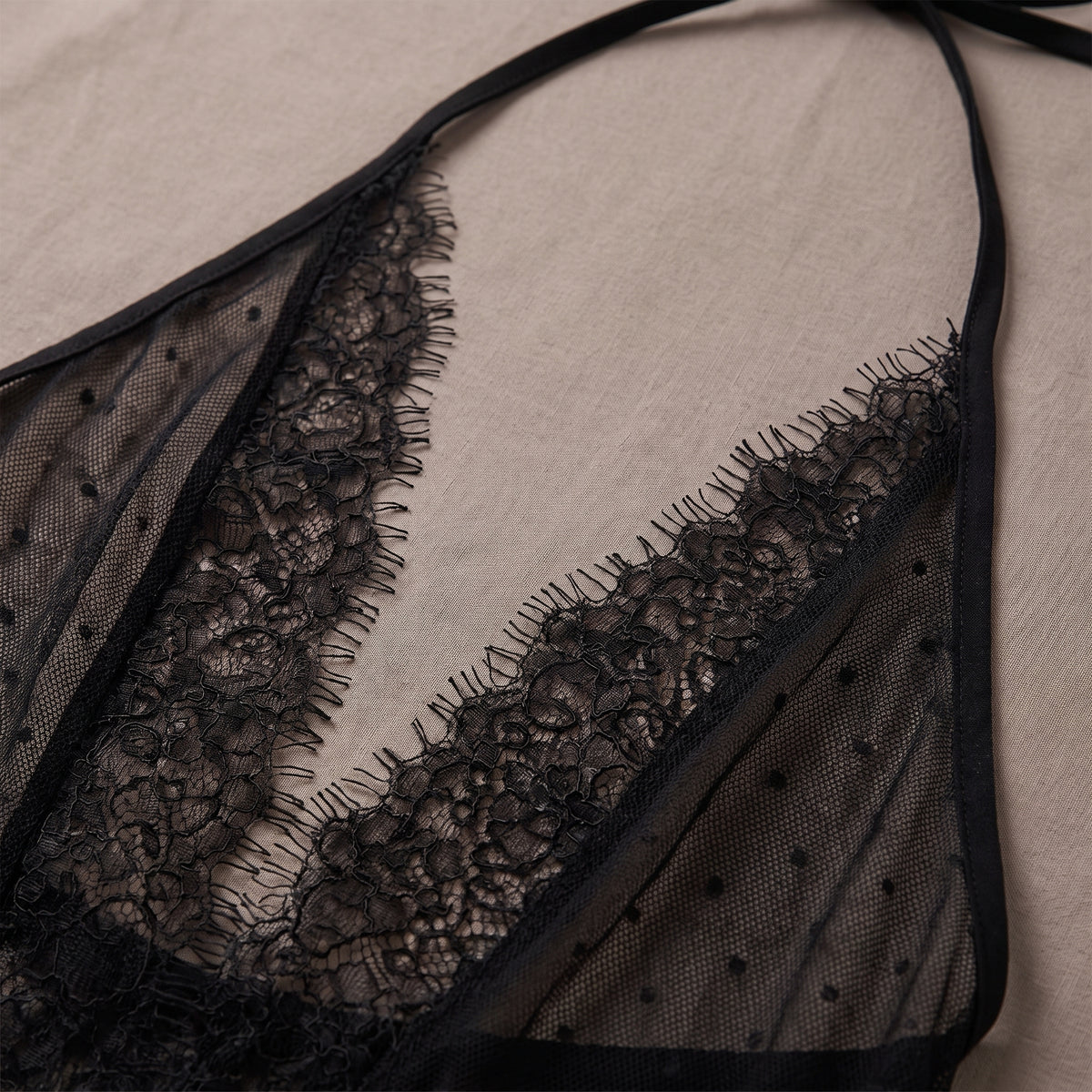 Détail du décolleté en V bordé de dentelle à cils et de l'encolure halter