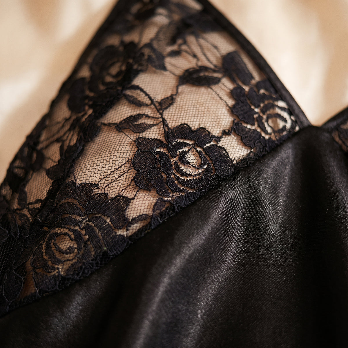 Détail de la dentelle noire transparente sur le satin noir