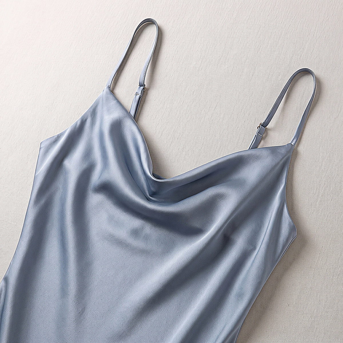 Détail de l'encolure drapée et des fines bretelles de la nuisette