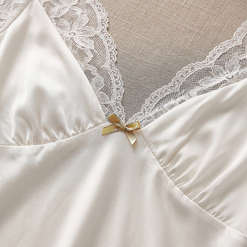 Détail du décolleté en V en dentelle et du petit noeud doré