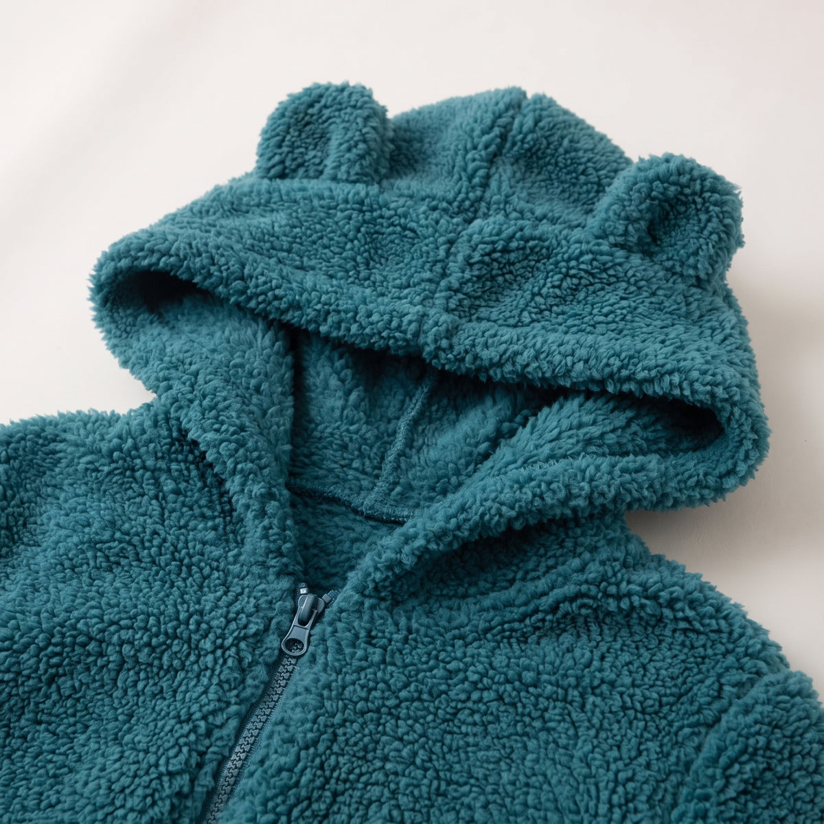 Détail de la capuche à petites oreilles et du col zippé en polaire teddy