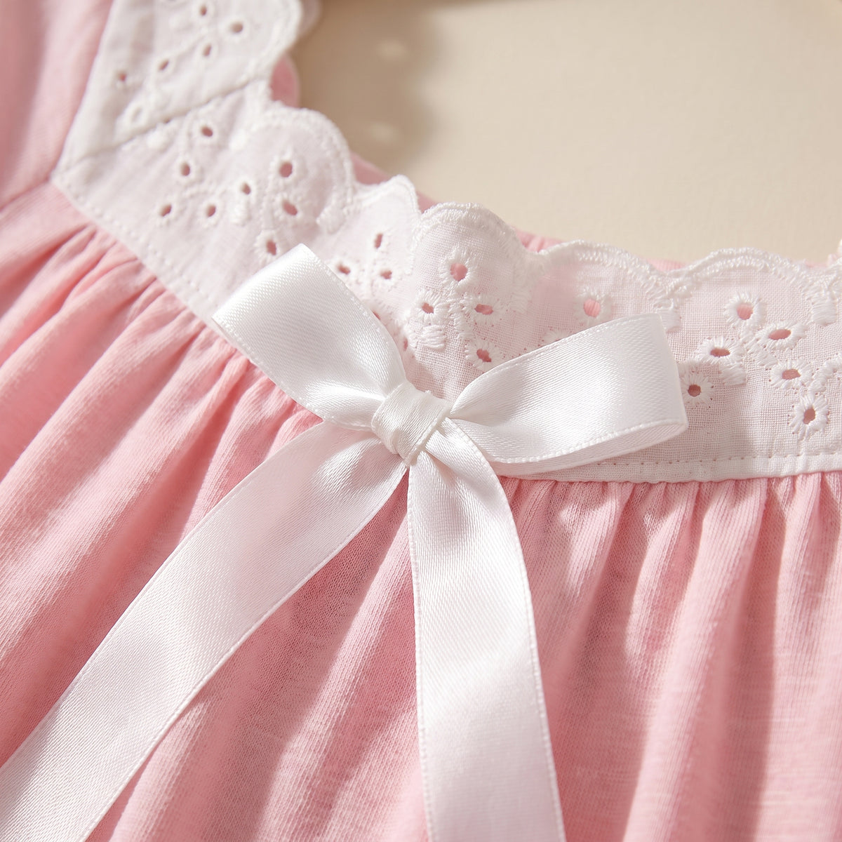 La douceur du coton et le détail de dentelle blanche et ruban de la chemise de nuit rose poudré