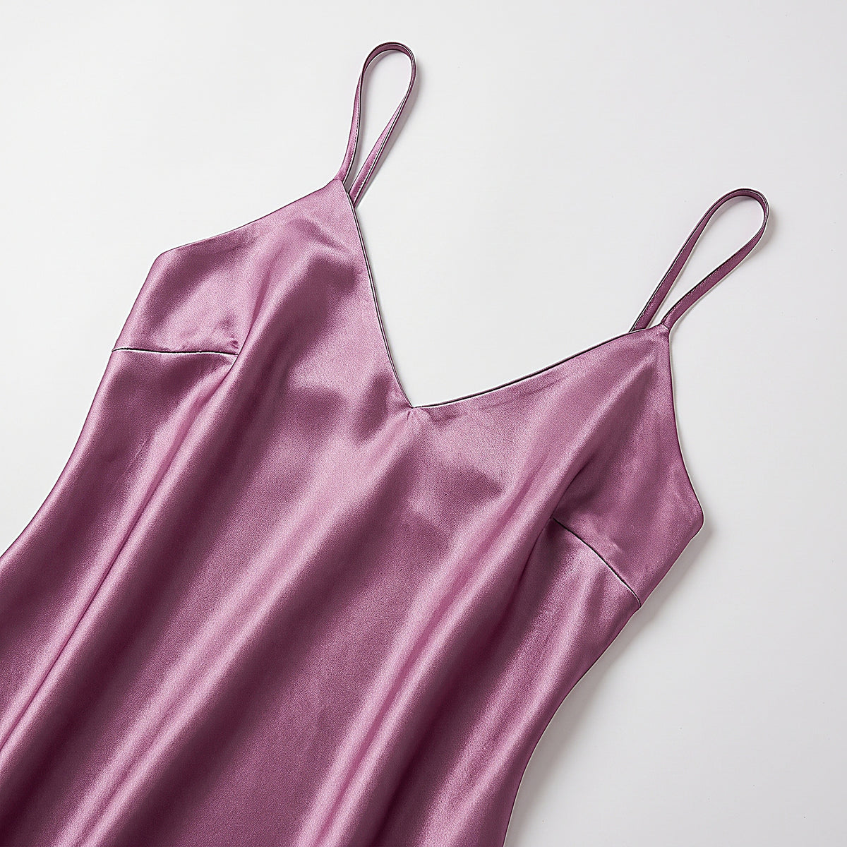 Détail du haut de la nuisette en satin mauve et de ses fines bretelles