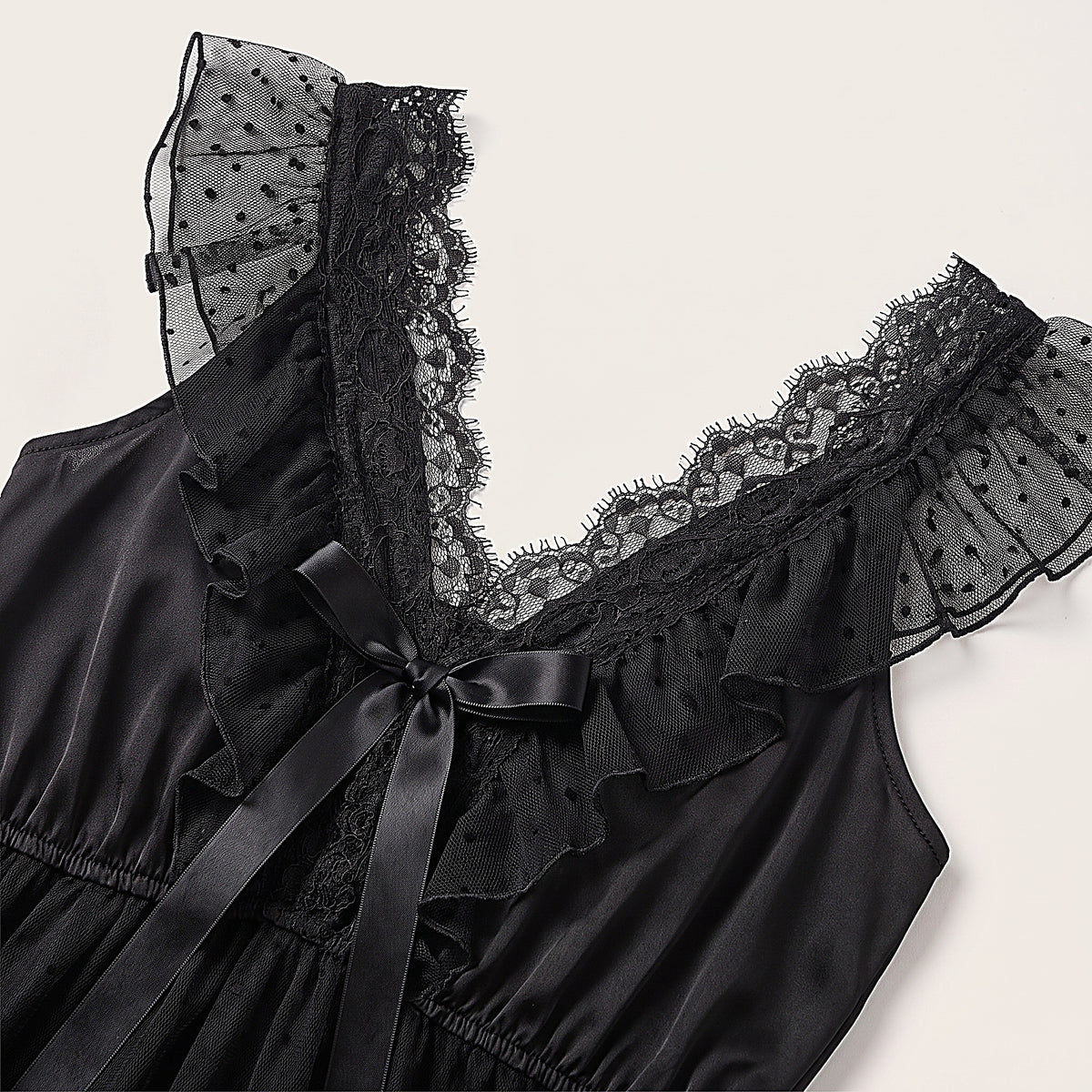 Détail du décolleté en V à dentelle, du volant de tulle et du noeud satin