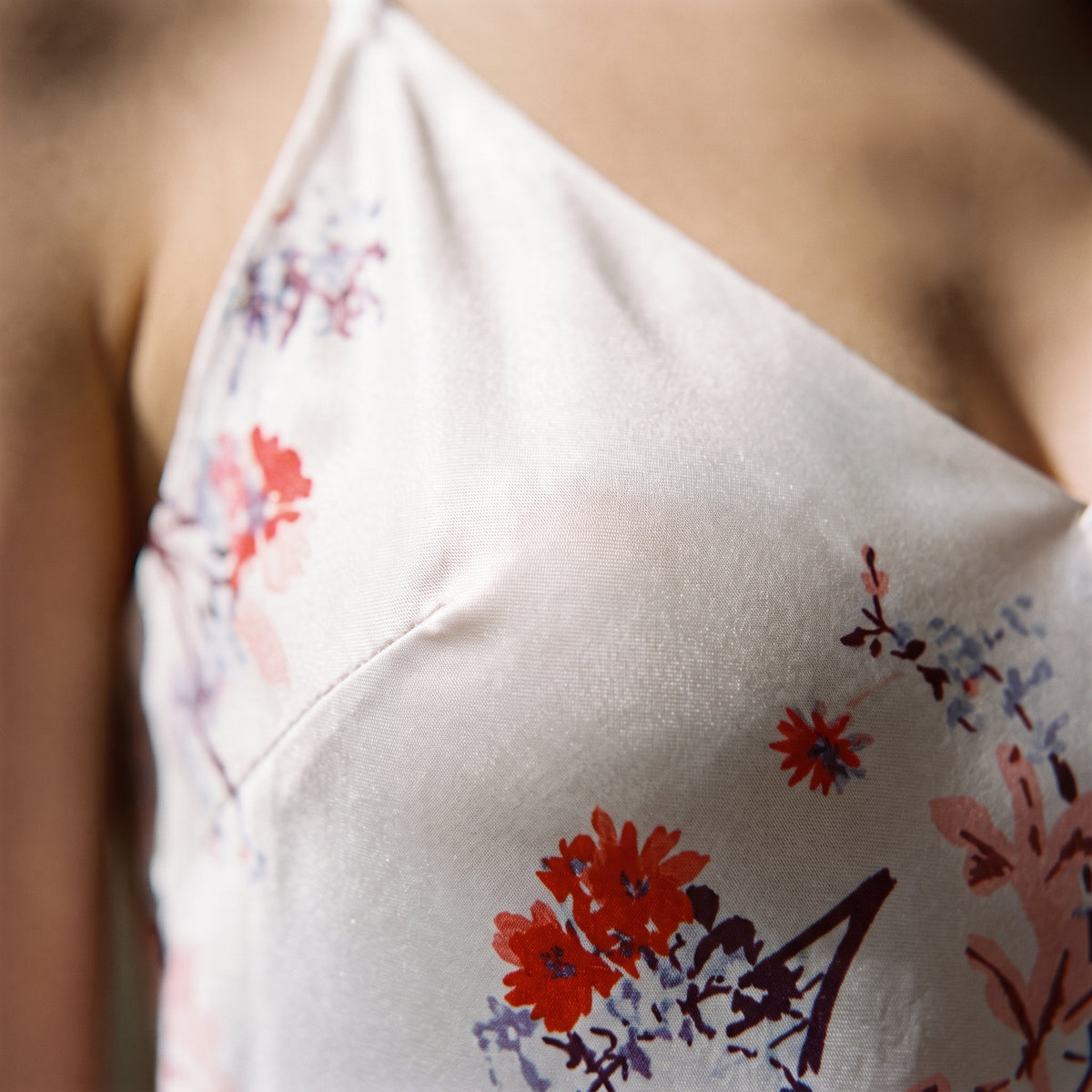Gros plan de l'imprimé floral délicat de la nuisette en satin rose