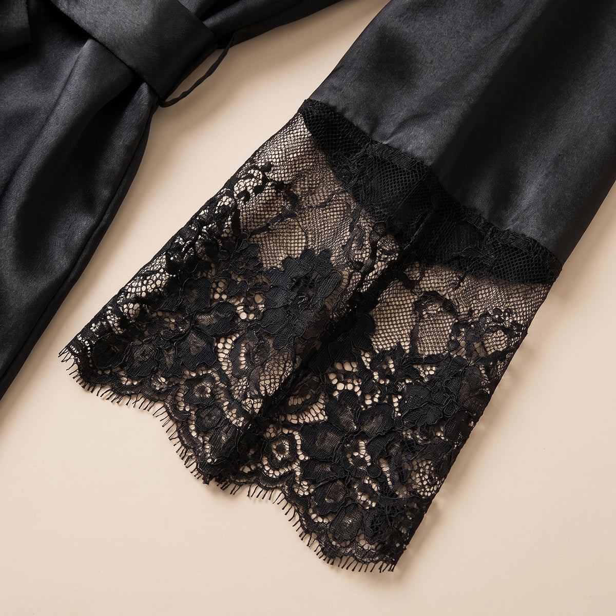 Détail de la manche évasée à volant de dentelle florale noire