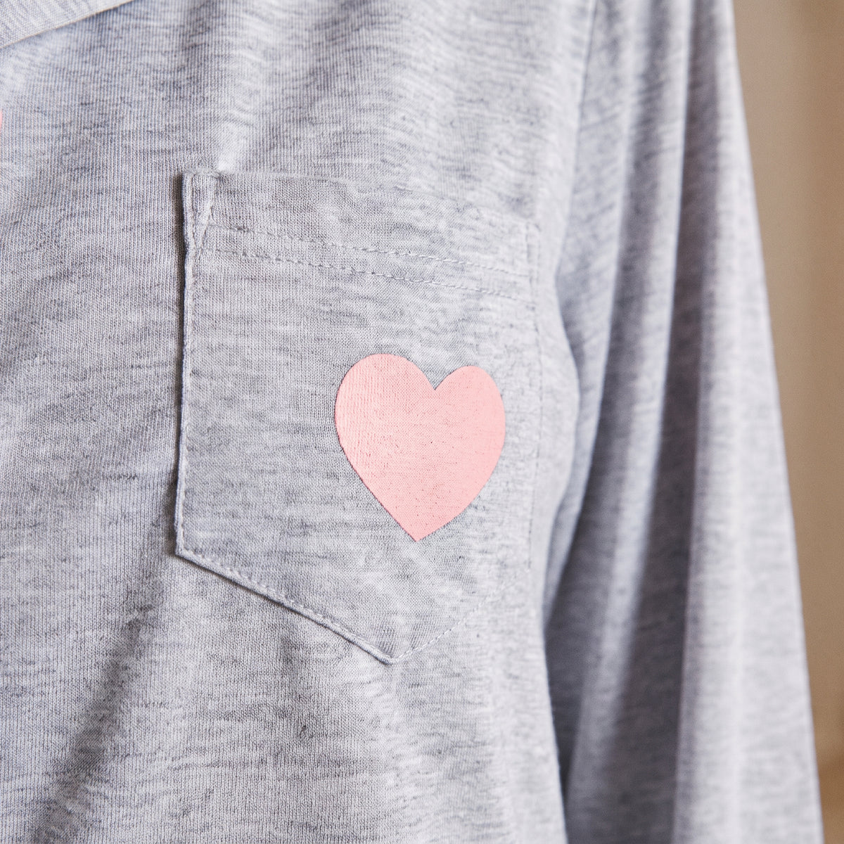 Cœur rose sur la poche de la chemise de nuit femme grise