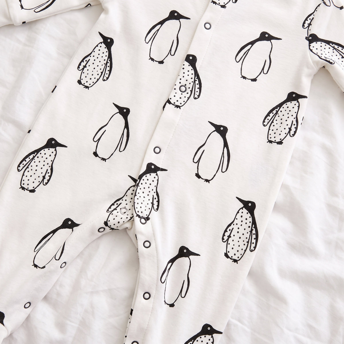 Rangée de pressions blanches qui ouvre tout le bas du pyjama de bébé