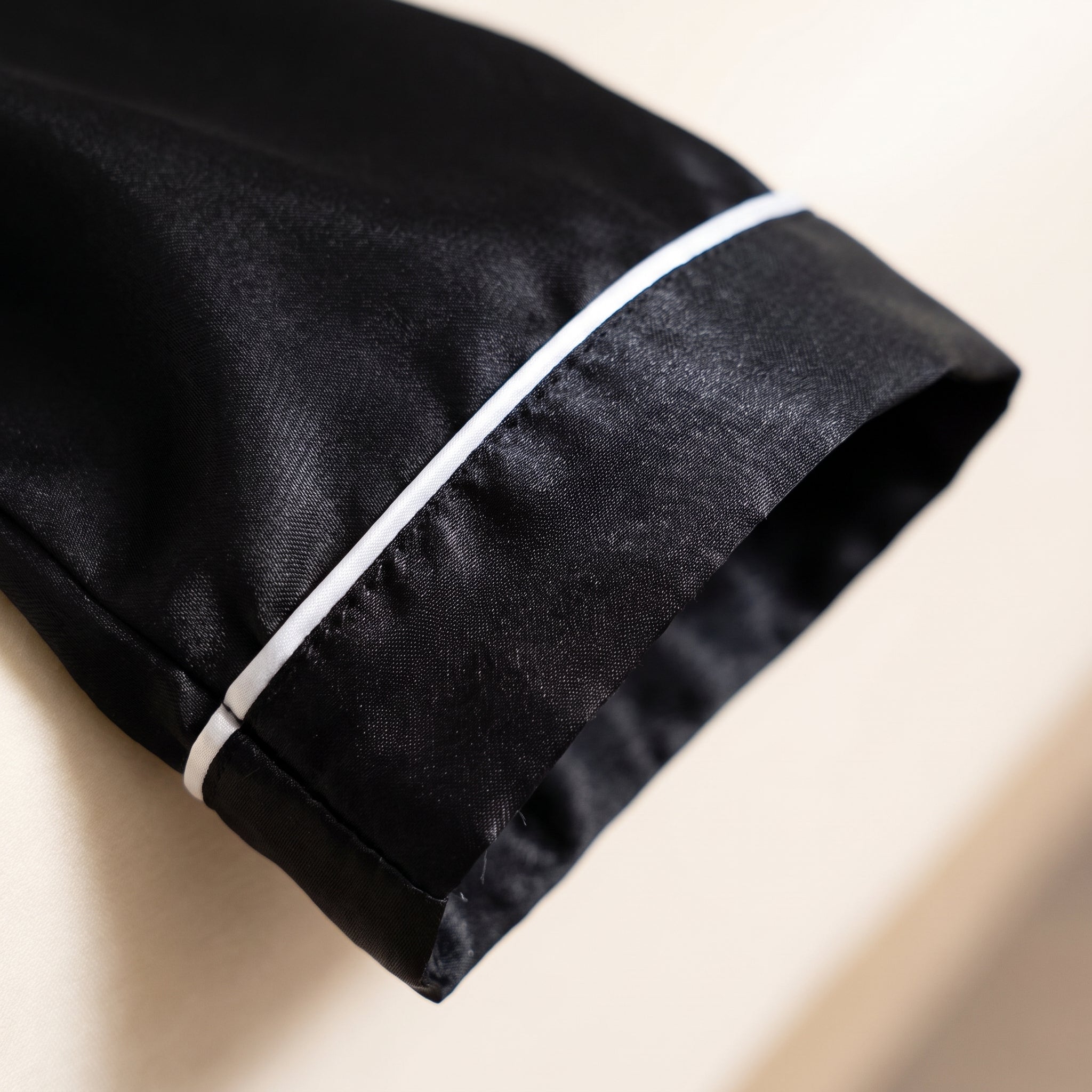 Gros plan lisere blanc au poignet de la robe de chambre satinee Image