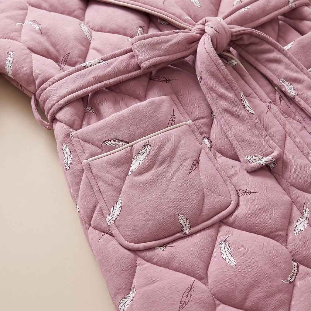 Détail de la poche plaquée et de la ceinture nouée du coloris rose à plumes
